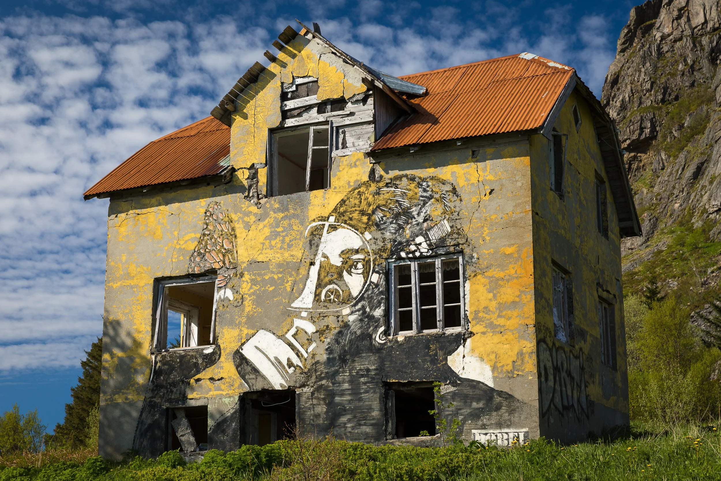 Street art by Pøbel in the Lofoten Islands, Norway – bold stencil art blending with the harbour landscape.