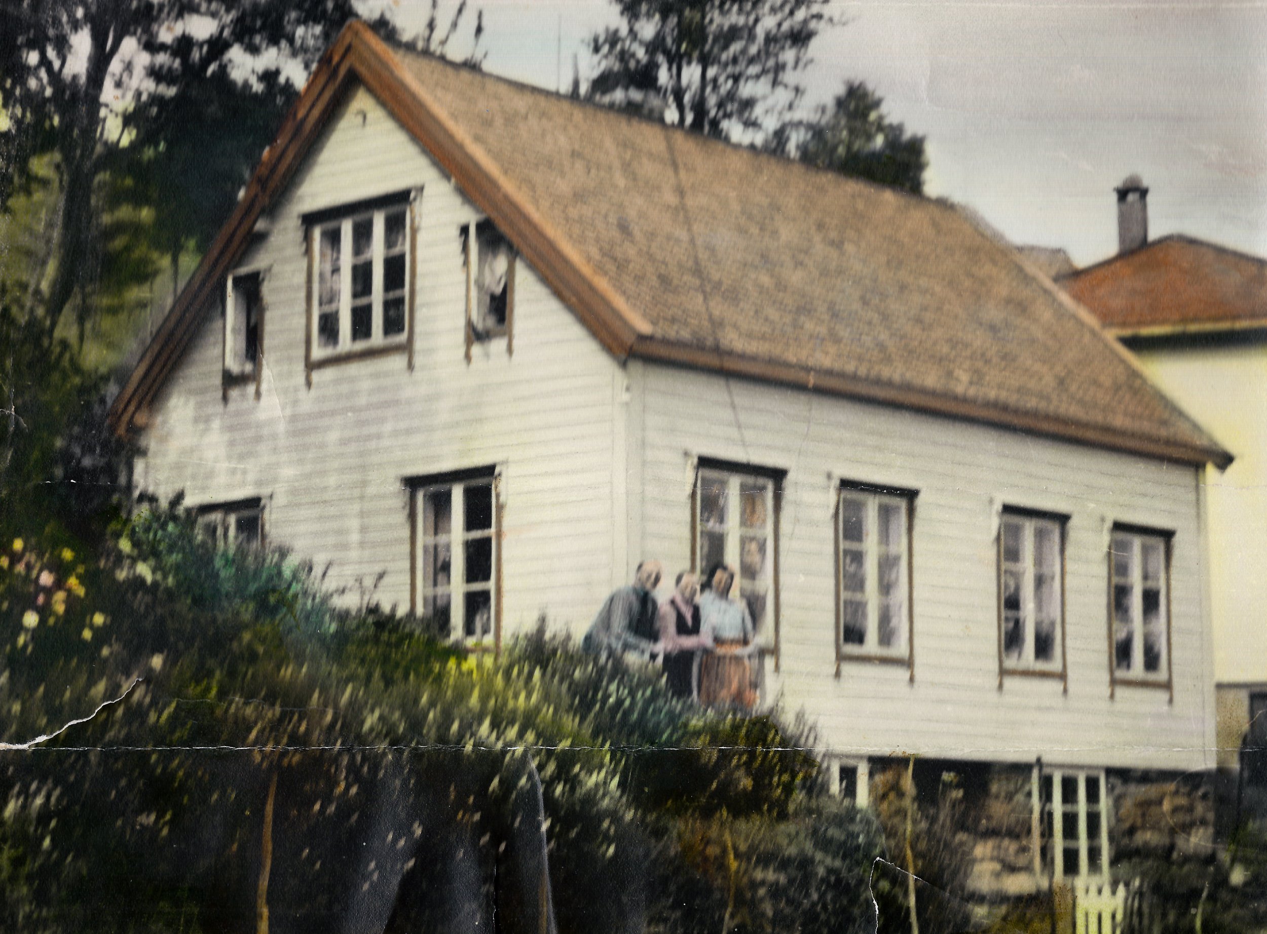 Hus i Husevåg, bygd ca. 1910 – det eldre huset og hageområdet dokumenterer byggeskikk og hverdagsmiljø på Husevågøy tidlig på 1900-tallet. Slike hjem var ofte knyttet til småbruk, dyr, hage og arbeid både på land og ved sjøen. Kilde/eier: familiealbu