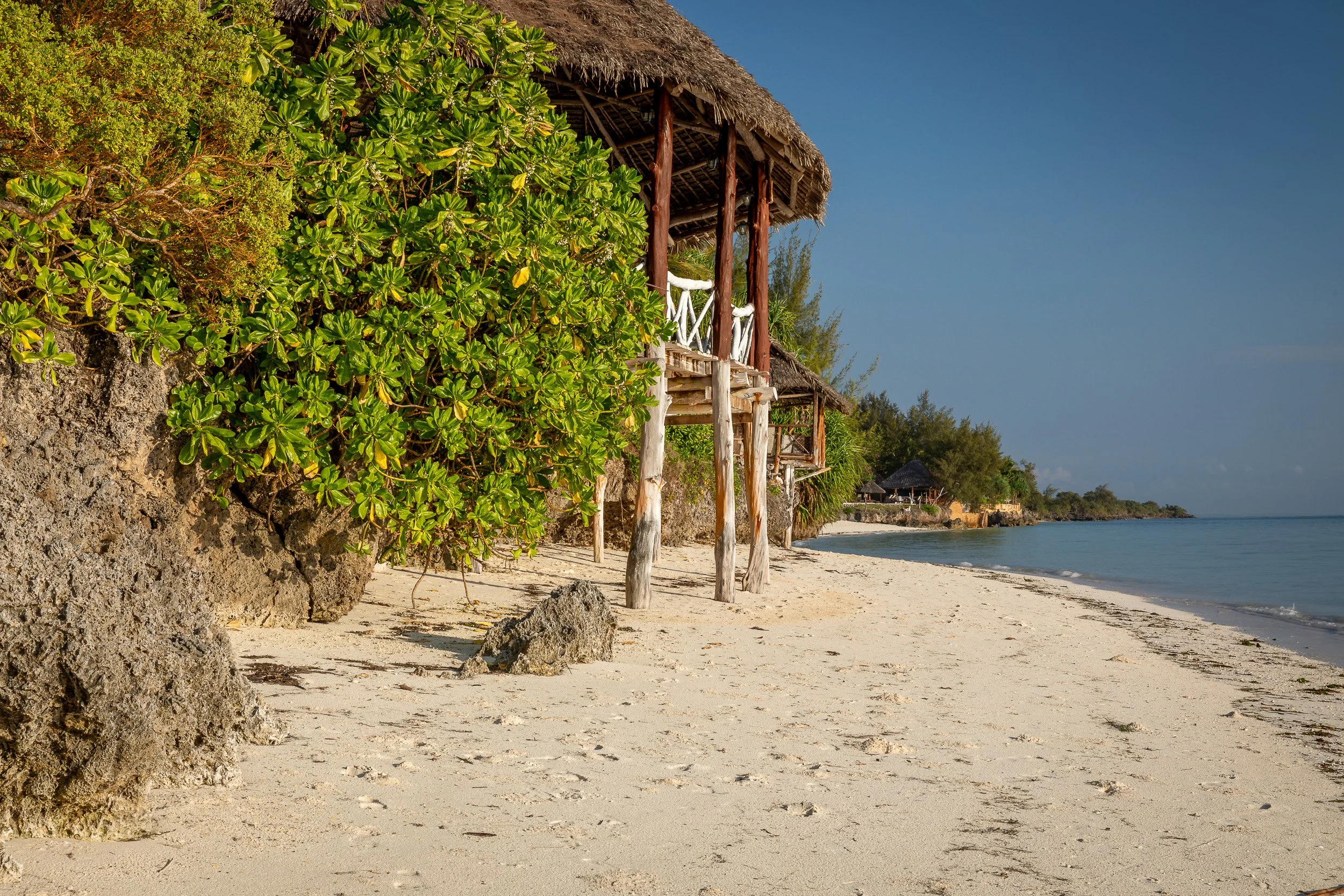 Chwaka Bay, Zanzibar – wide turquoise lagoon at low tide, sandbanks and a distant palm-lined shore under a big tropical sky.