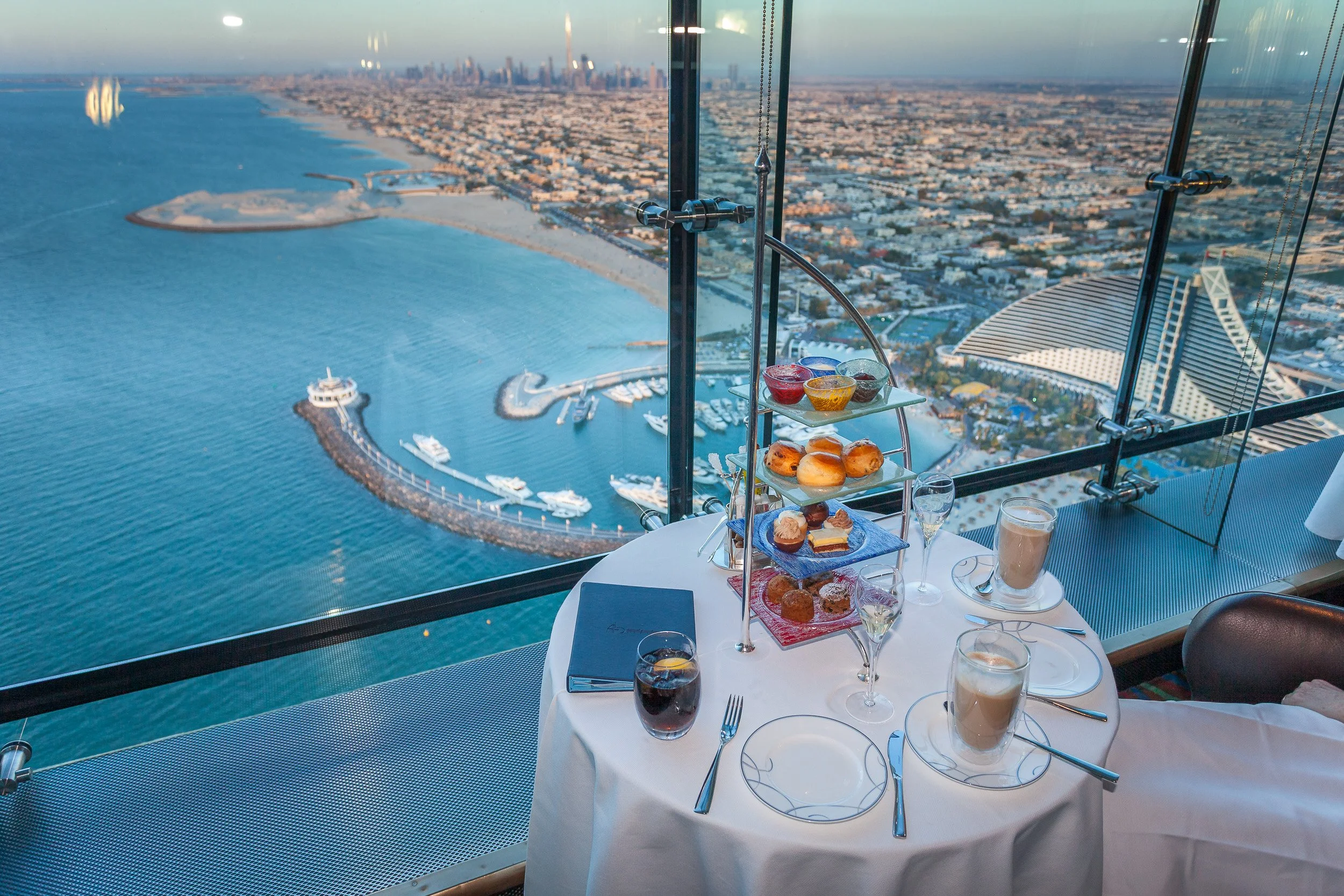 Afternoon tea at the top of Burj Al Arab, served with sweeping views across the Arabian Gulf and Dubai’s distant skyline.