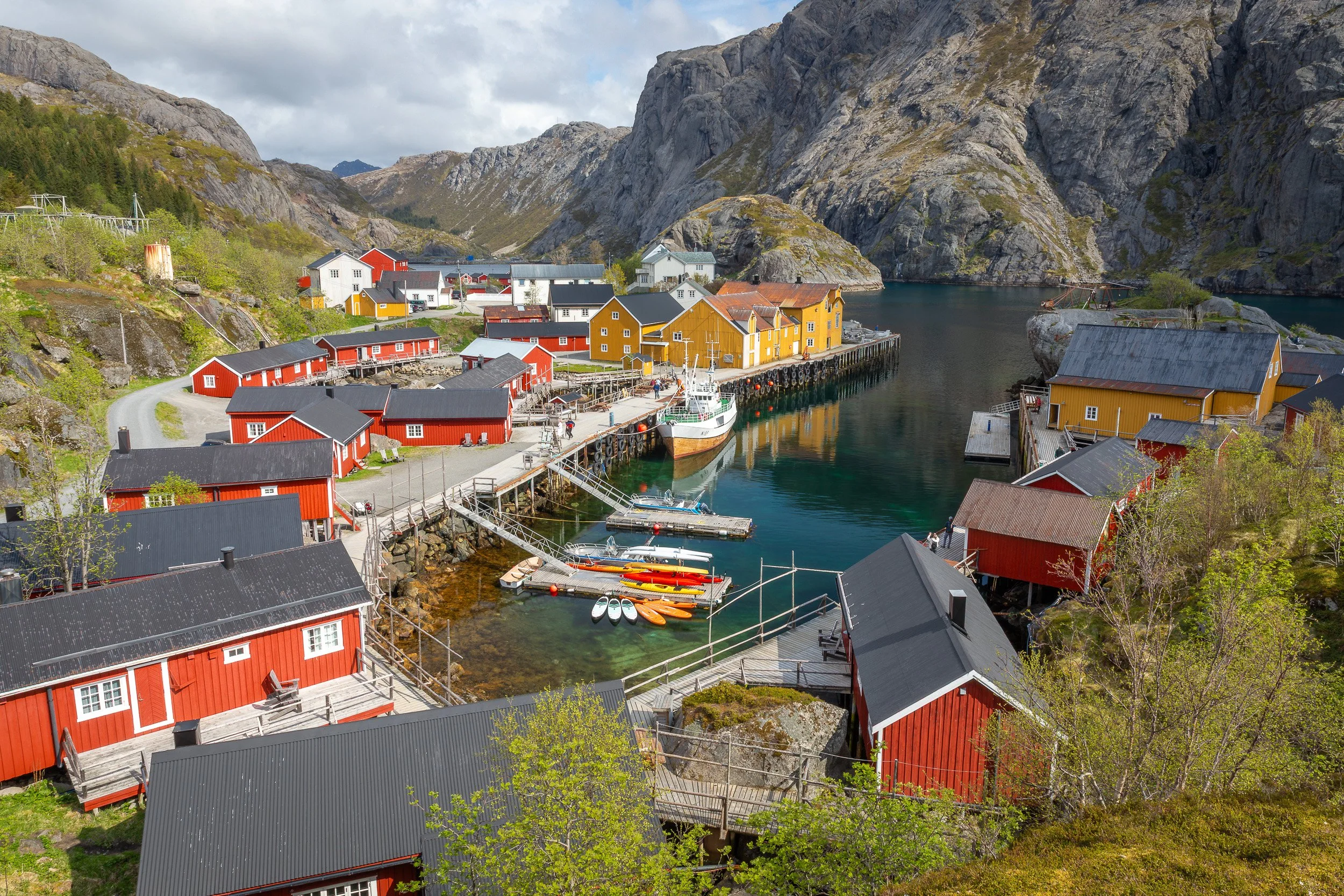 Fisherman’s cabins in Nusfjord, Lofoten Islands, Norway – yellow and red houses grouped tightly around a sheltered fjord.