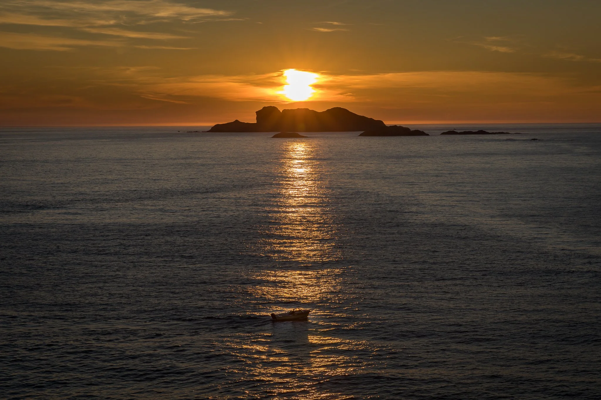 Sunset over Klovningen seen from Husevågøy, with evening light fading across the Stad Sea and the outer coast of Nordfjord.