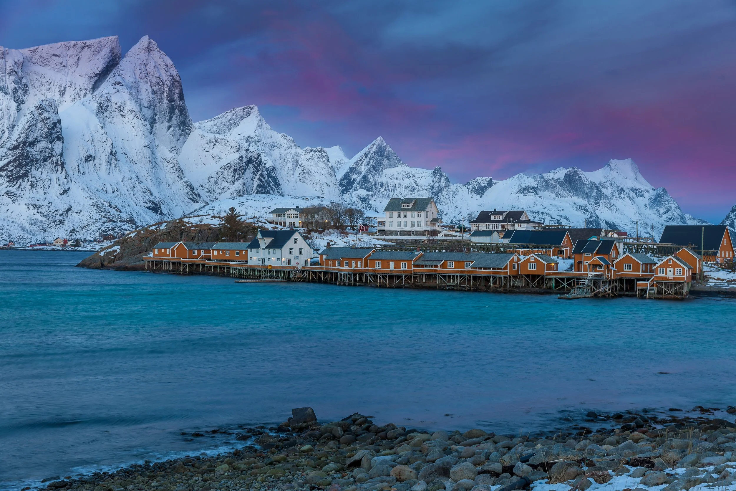 Early sunrise at Sakrisøy in the Lofoten Islands, Norway – soft pastel light on yellow houses, bridges and surrounding peaks.
