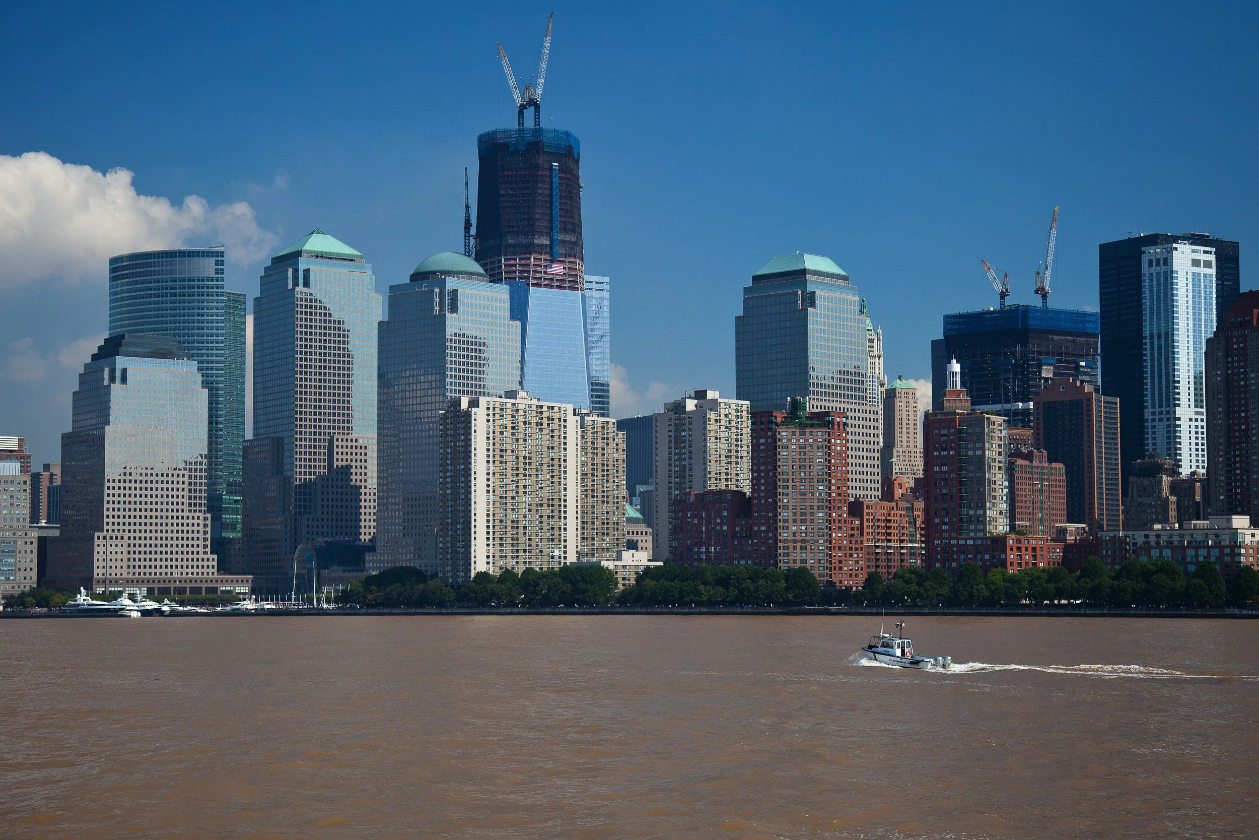 Lower Manhattan skyline with One World Trade Center still climbing skywards above the Hudson.