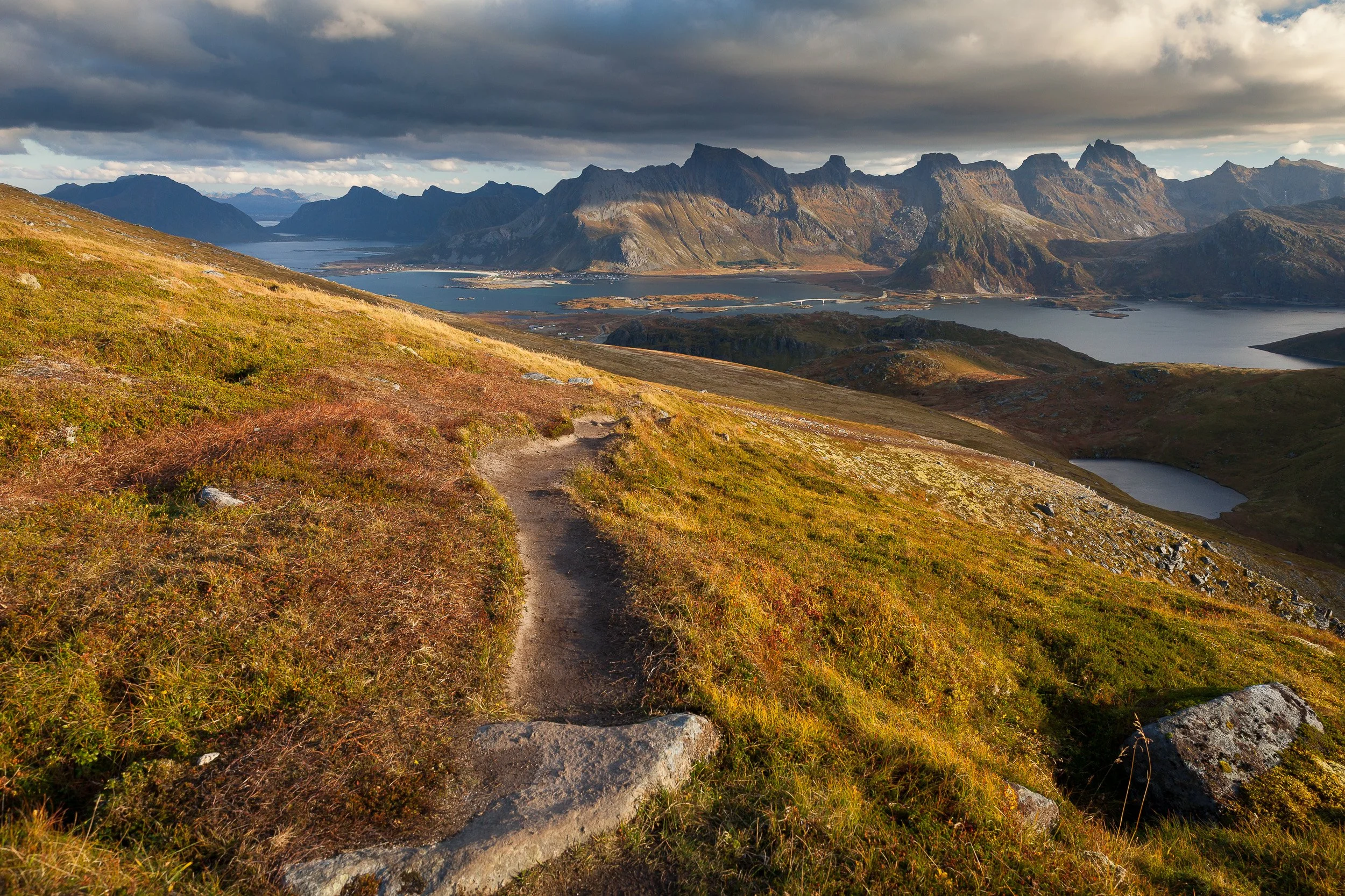 Hike from Ryten in the Lofoten Islands, Norway – cliffside trail with sweeping views over beaches and mountains.