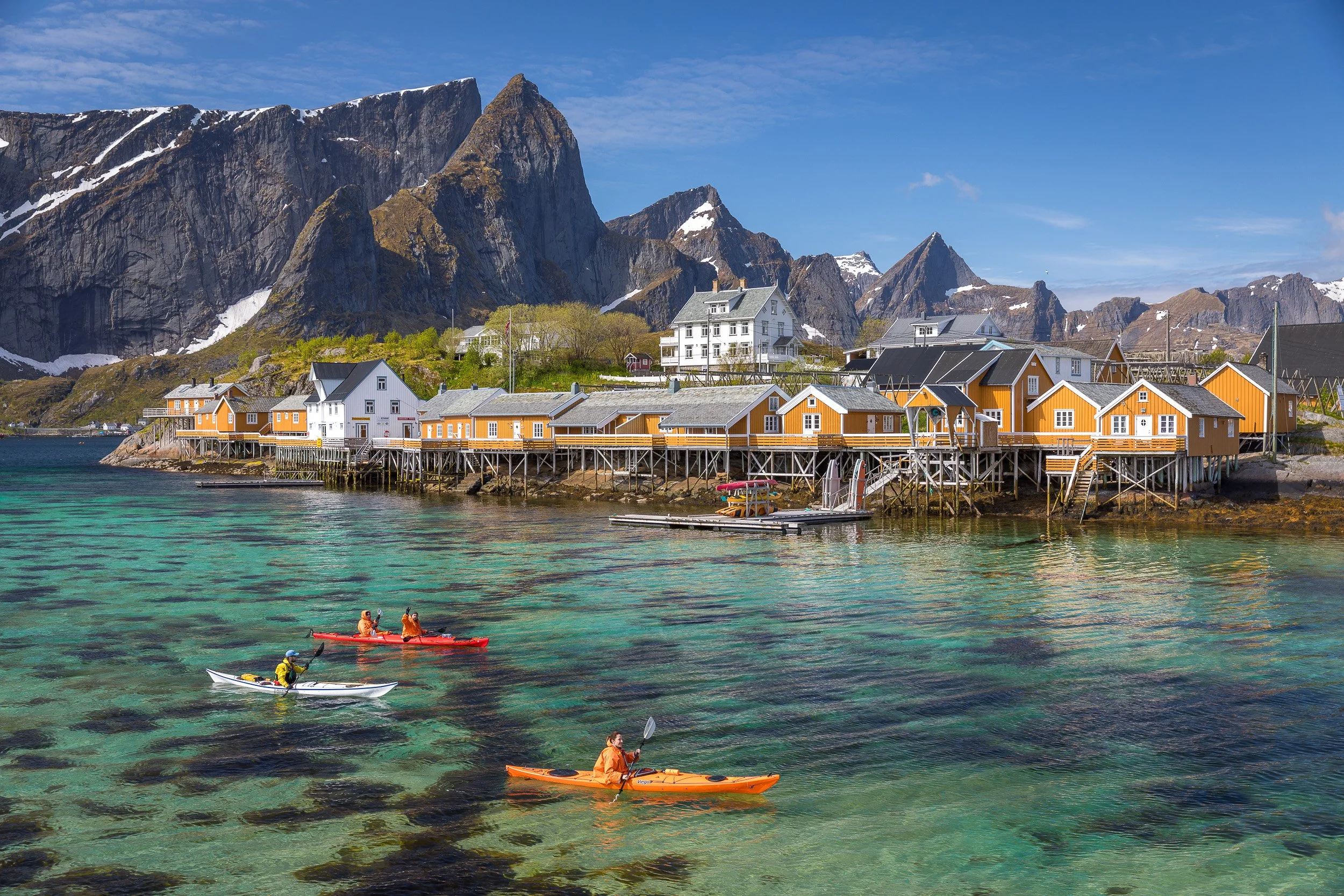 Sakrisøy in the Lofoten Islands, Norway – small island community with bright yellow houses and clear emerald water.