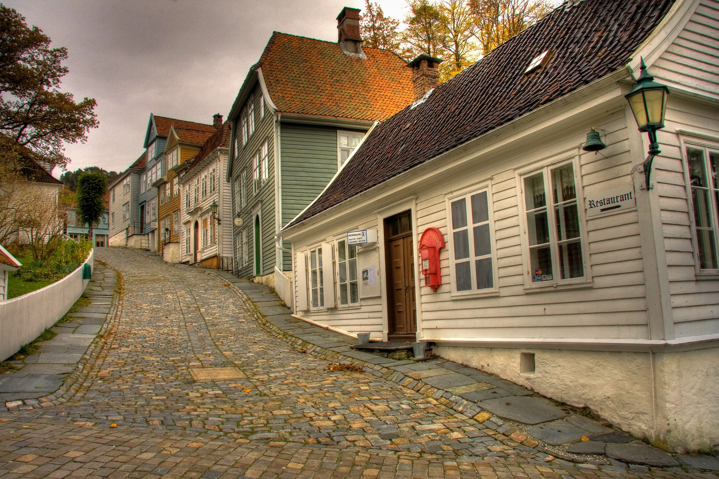Cobbled lanes and painted timber houses in Gamle Bergen (Old Bergen) Museum in Sandviken — an open-air “town” built from around 50 relocated wooden buildings that recreate everyday Bergen street life from the 18th to 20th centuries.