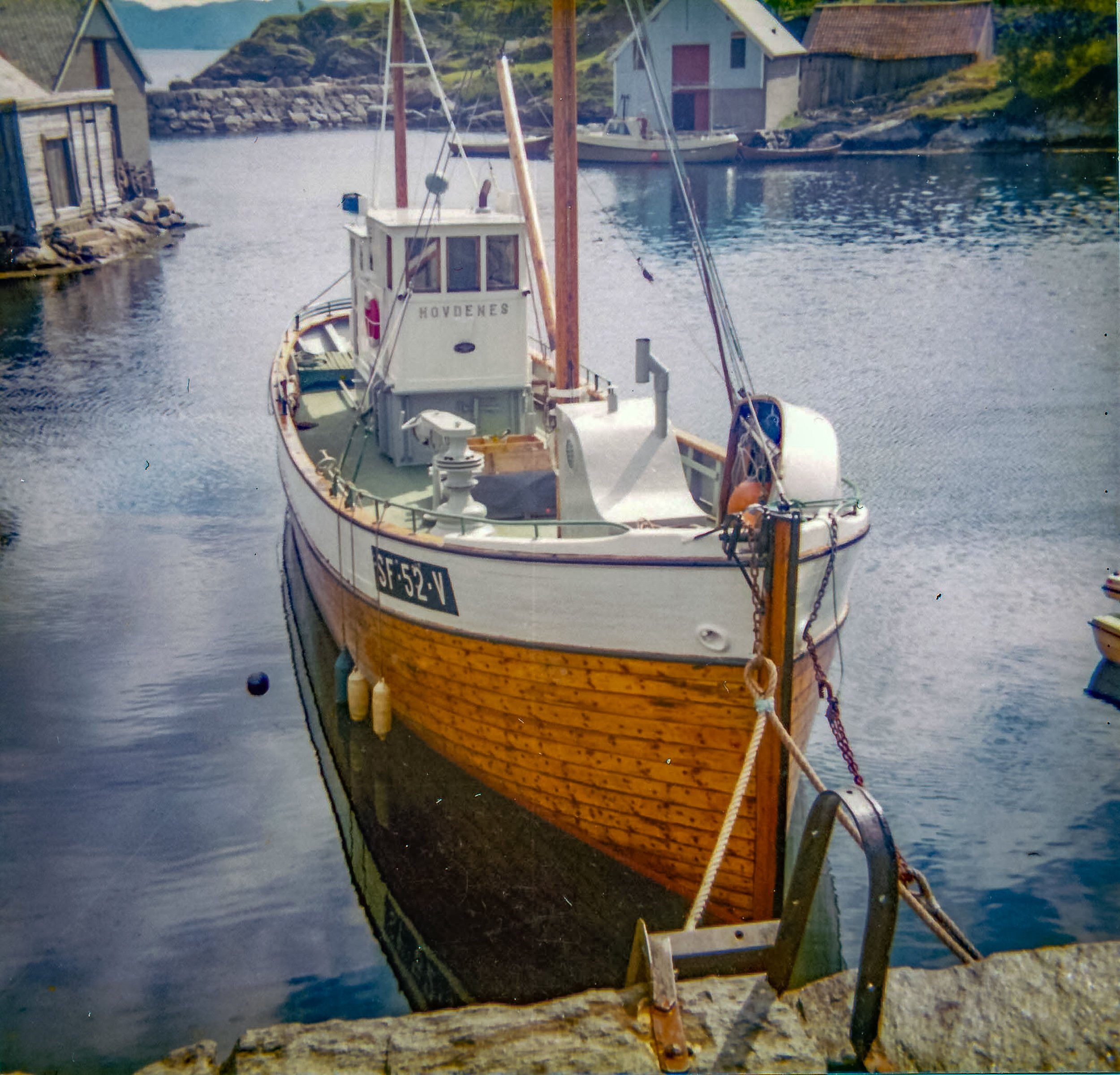 Motorkutteren «Hovdenes» med fiskerimerket SF-52-V, fortøyd innerst ved moloen i Husevåg.
