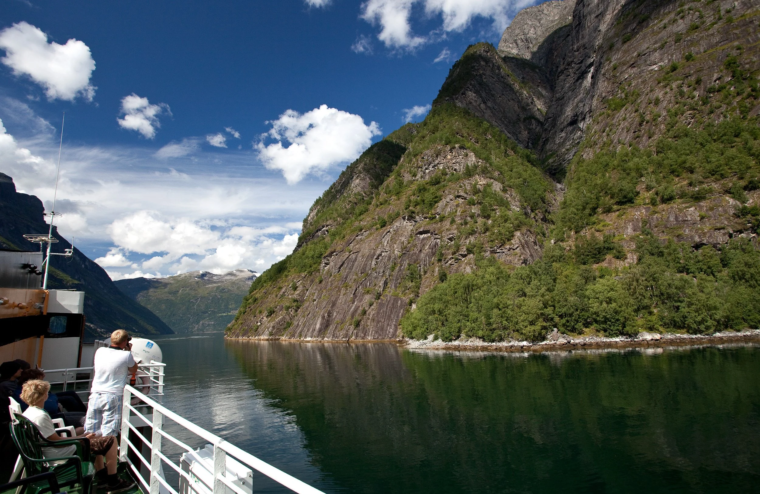 Geirangerfjord in perfect summer calm, where steep mountains funnel the light into one of Norway’s most iconic fjord corridors.