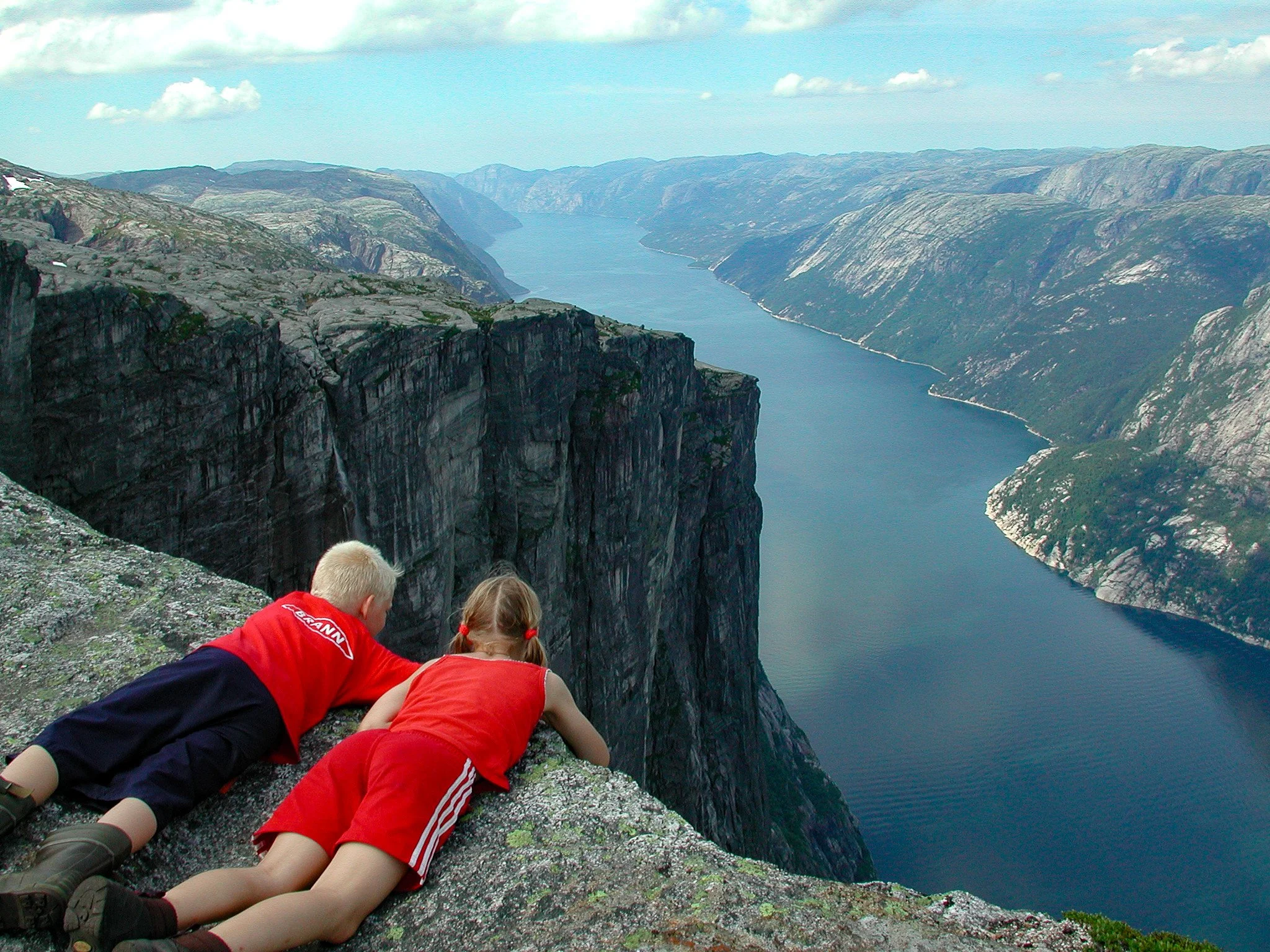 Two children hang right on the edge of Kjerag, 1,084 metres above sea level, peering nearly 1,000 metres down into the dizzying depths of the Lysefjord — Norway’s drama, in one heartbeat.