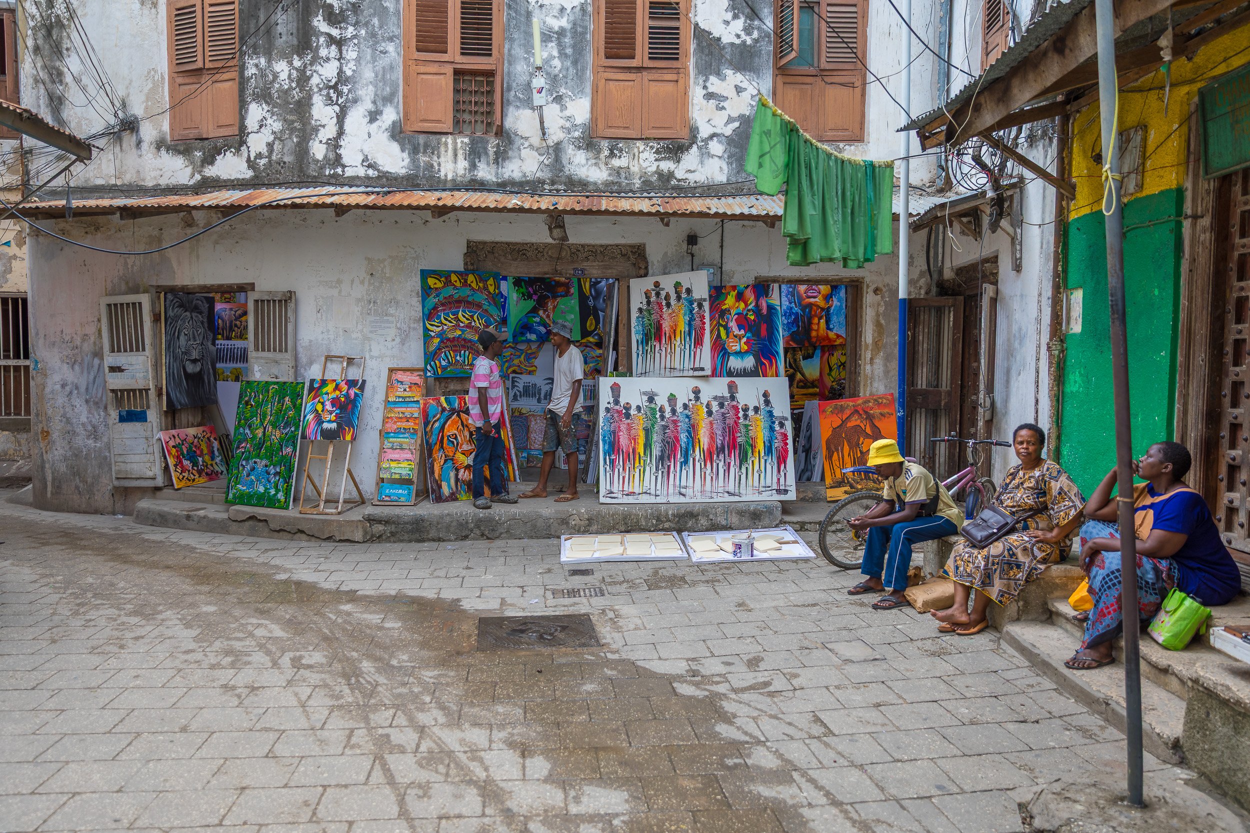 Historic streets of Stone Town, Zanzibar – traditional Swahili architecture with carved wooden doors and faded façades in warm tropical light.