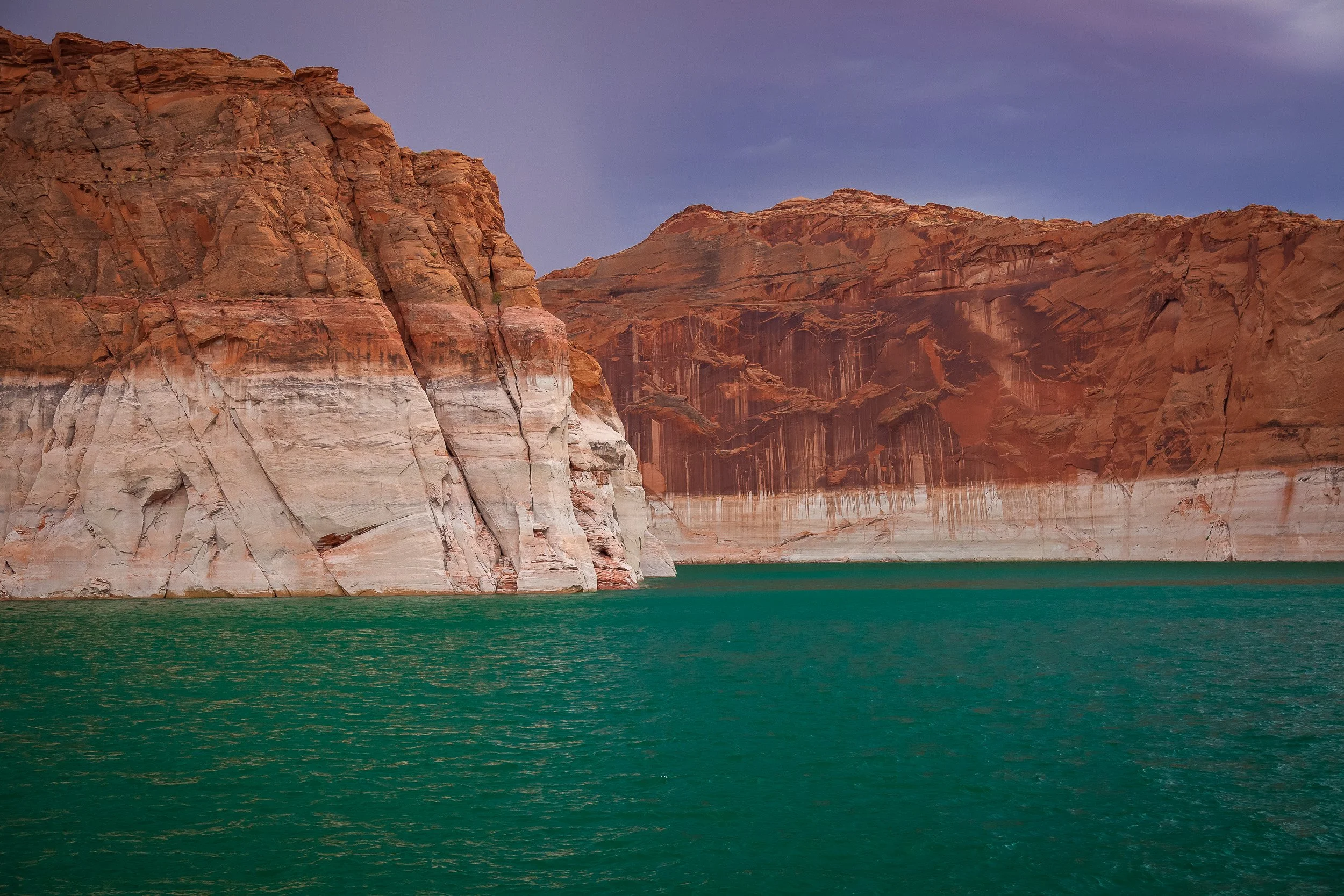 Red sandstone cliffs and turquoise water at Lake Powell, Arizona.