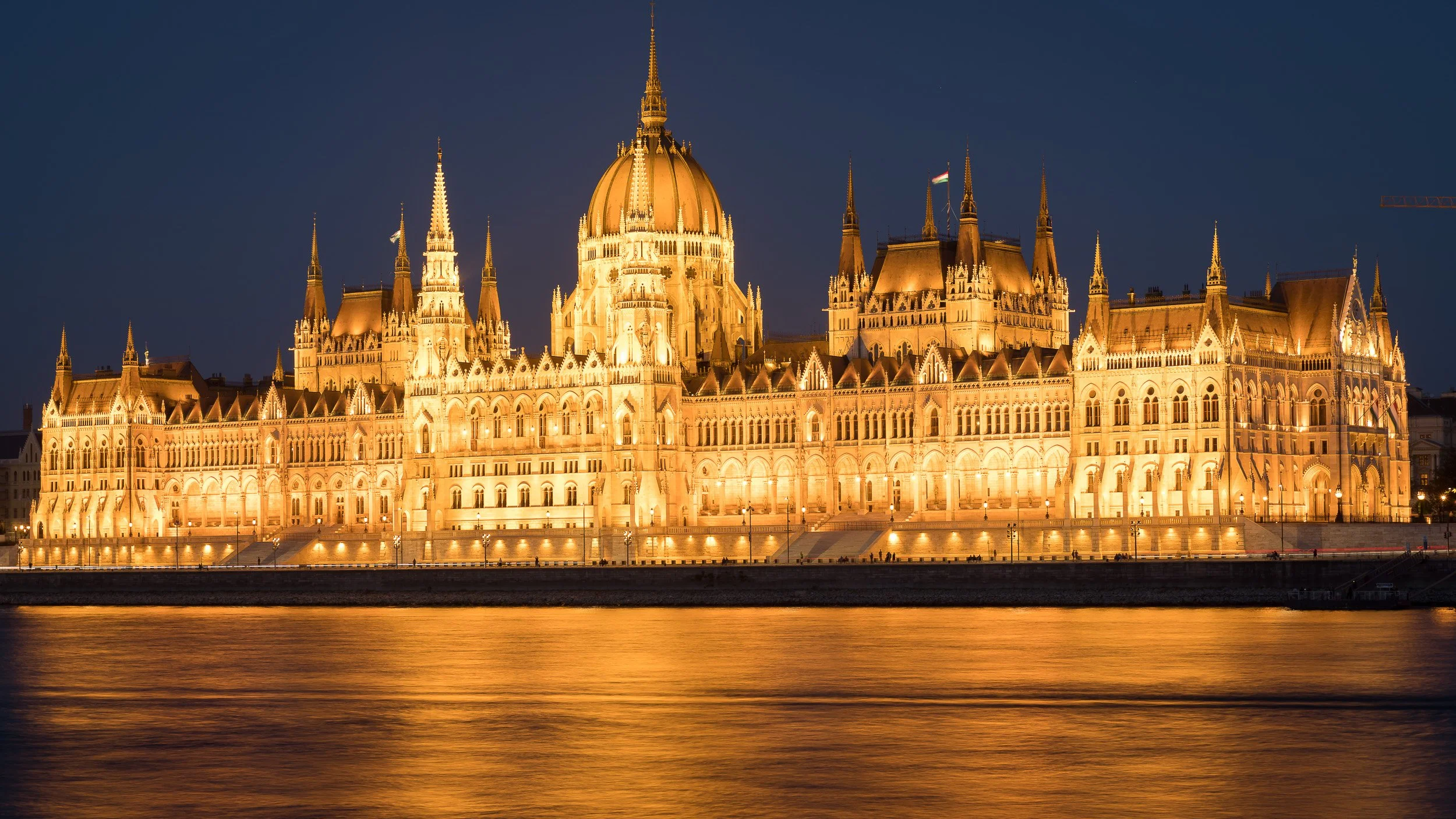 Hungarian Parliament Building on the Danube in Budapest, Hungary – golden lights reflected in the river during blue hour.