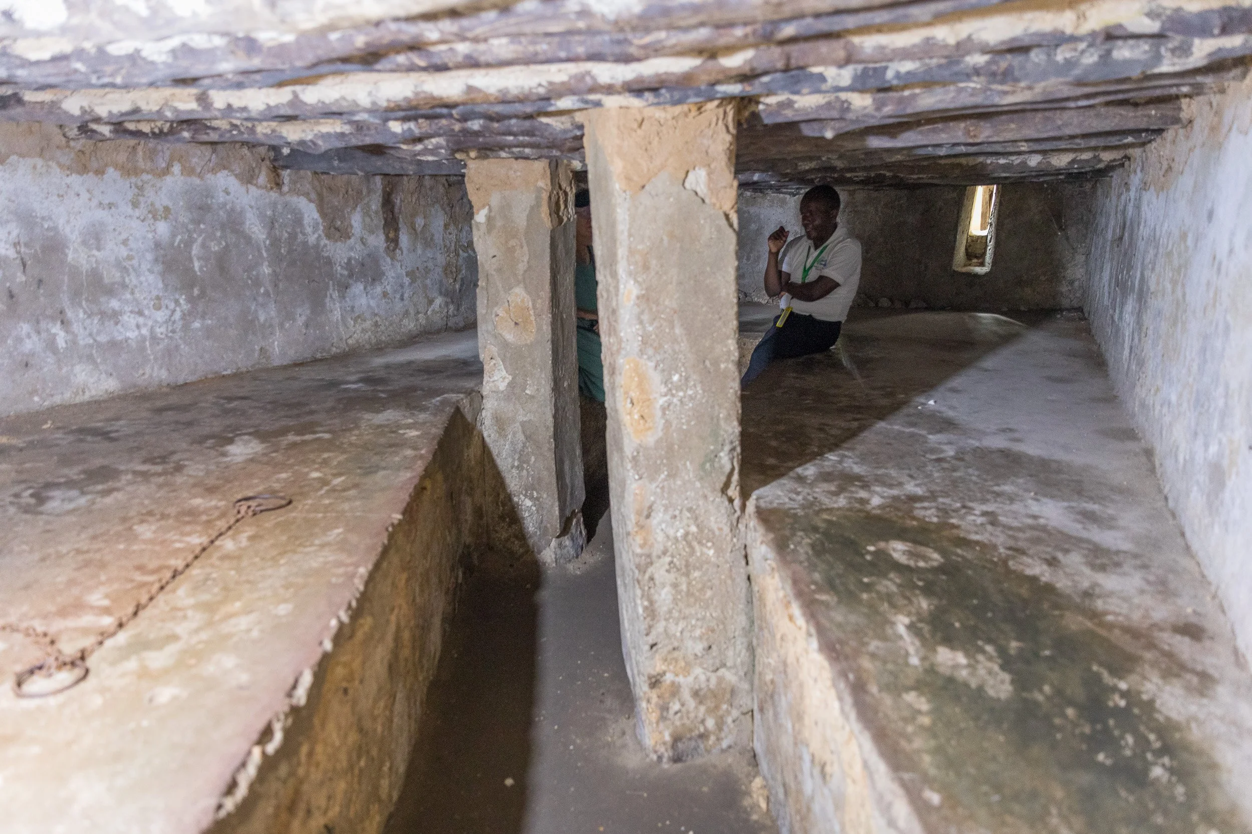 Former slave holding cell beneath the Anglican Cathedral in Stone Town, Zanzibar – cramped stone chamber with low ceiling and dim light evoking the island’s dark history.