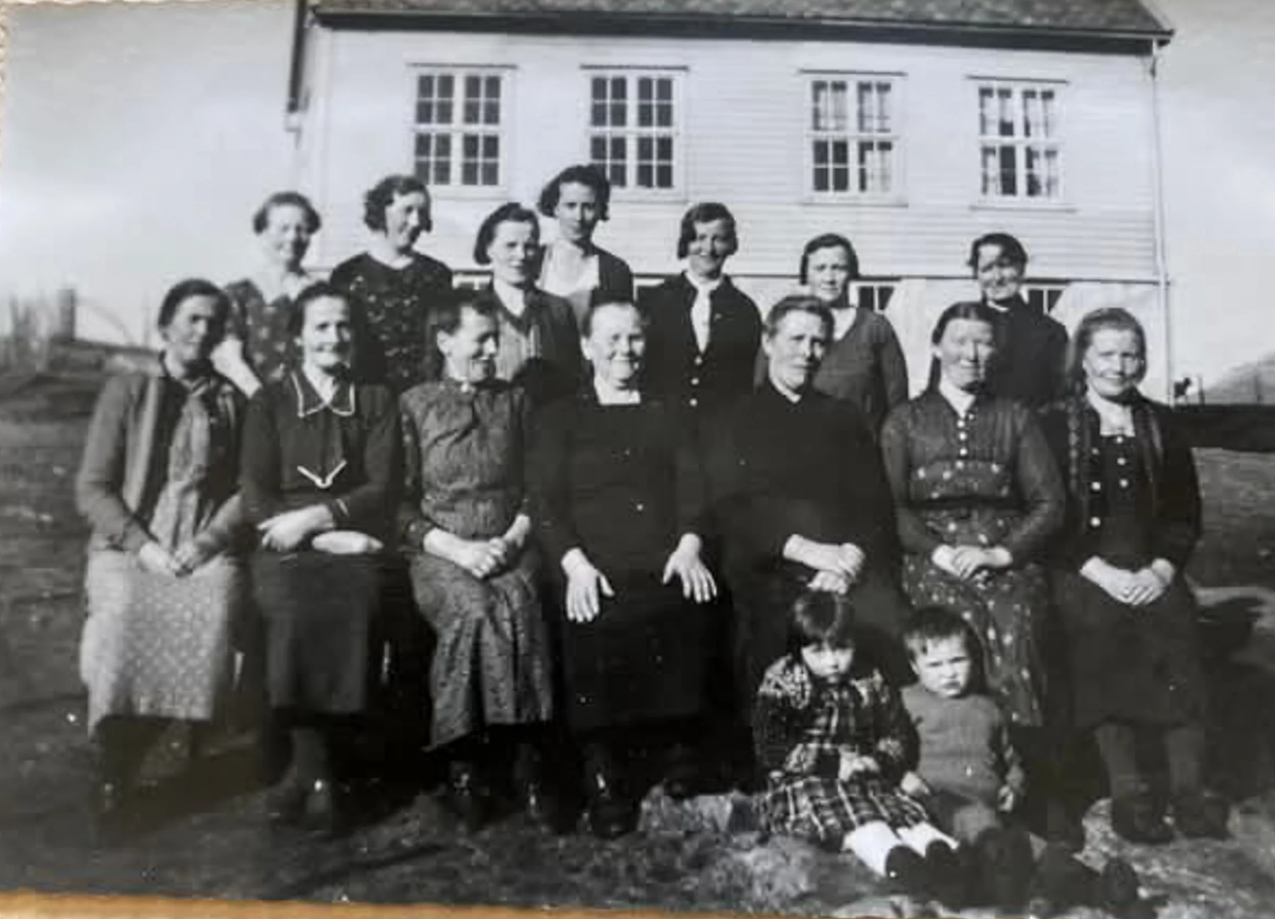 Historisk gruppebilde av kvinneforeningen Kveldsol foran skolehuset i Tytingvåg omkring 1940.