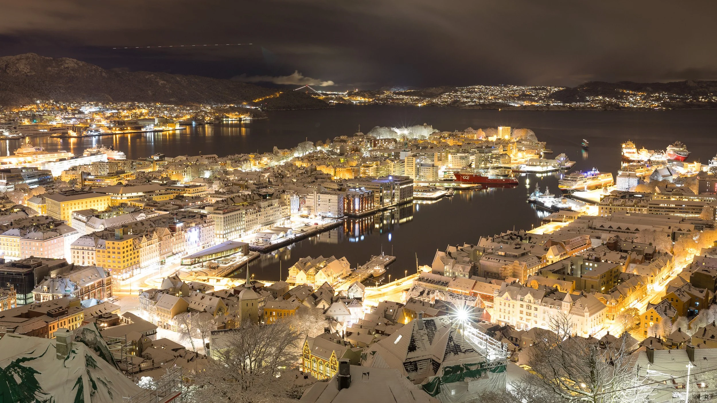 My hometown Bergen at night in Western Norway – harbour city between seven mountains with lights reflected in the water.