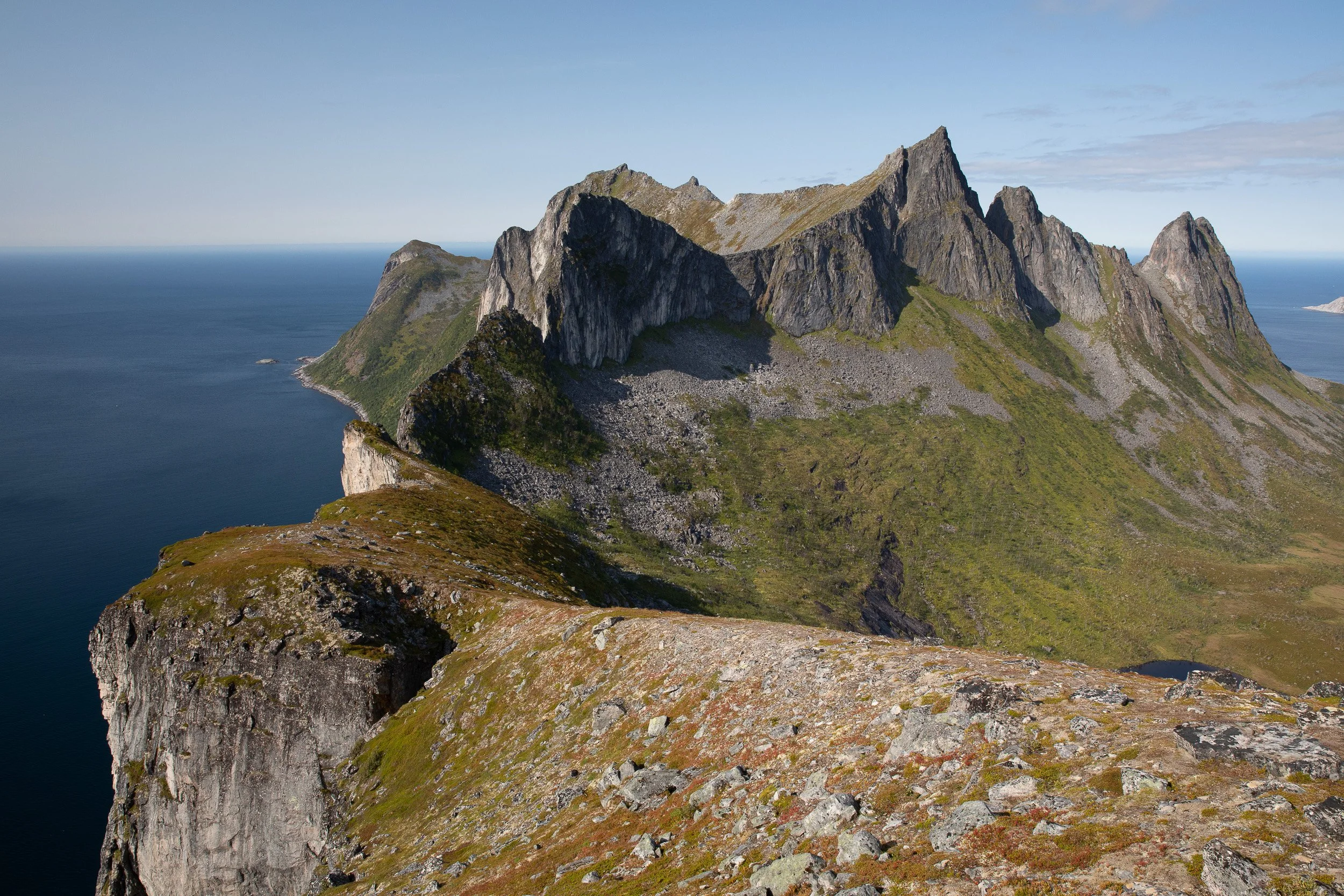A close view of Segla from the Hesten ridge, with the mountain’s sheer rock wall standing between sheltered fjord water and distant peaks.