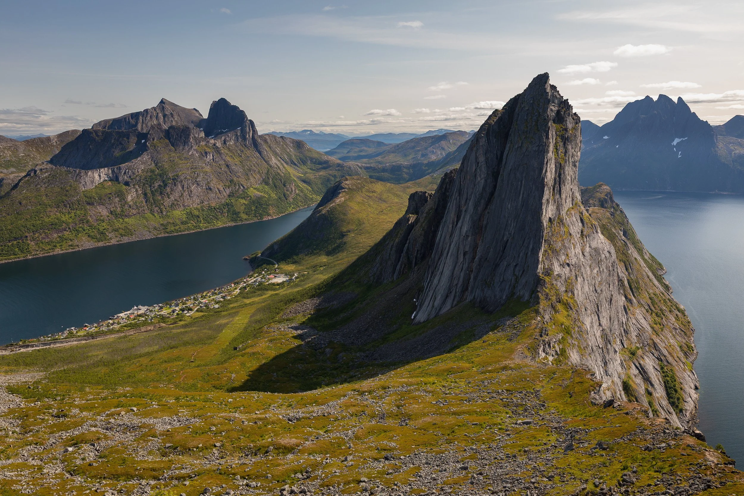 Segla rises sharply above Mefjorden, its vertical rock face dividing the fjord, village and surrounding peaks in one of Senja’s classic mountain views.