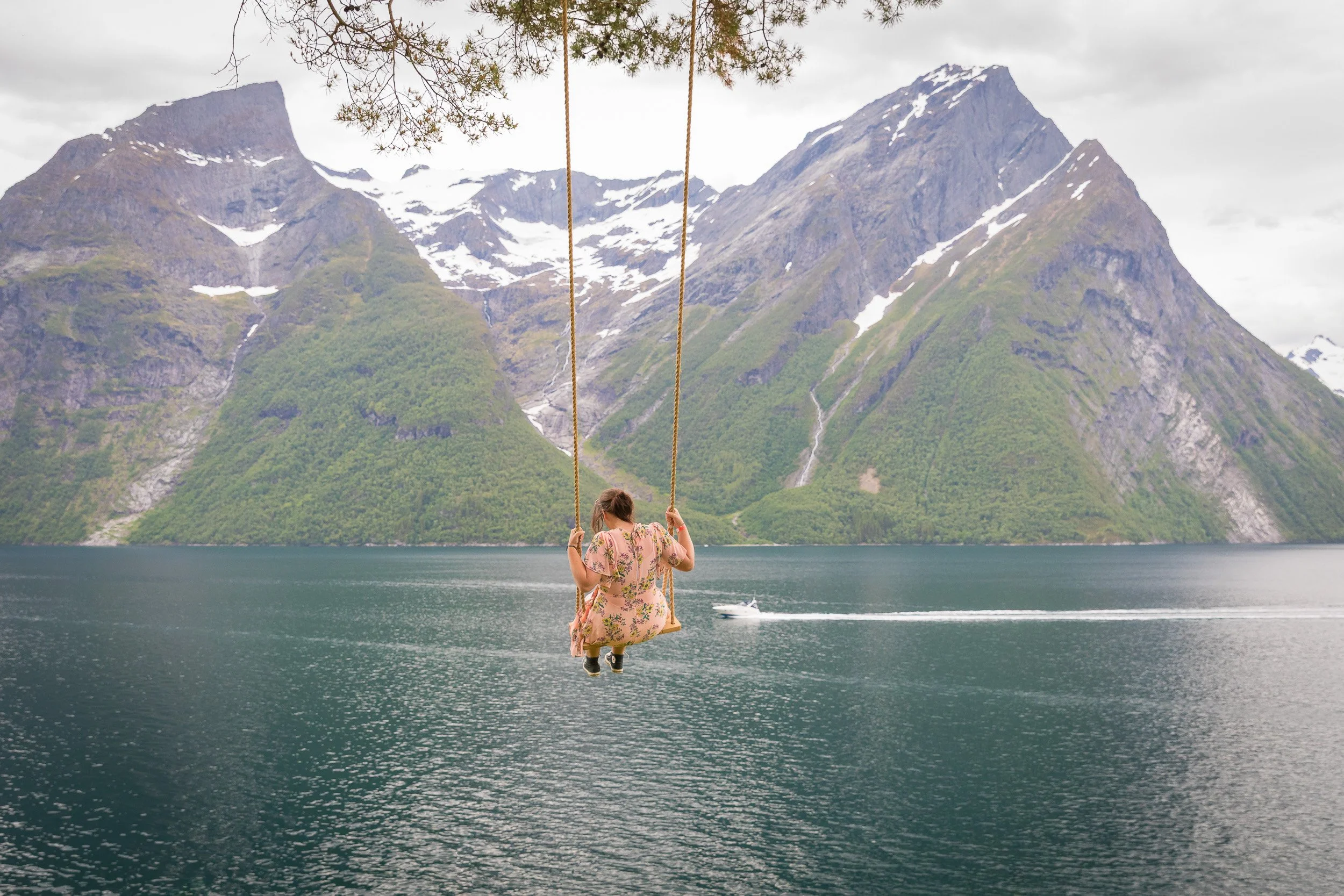 Trandal in Hjørundfjorden — the famous fjord swing, hanging over deep water with mountains rising like walls behind.