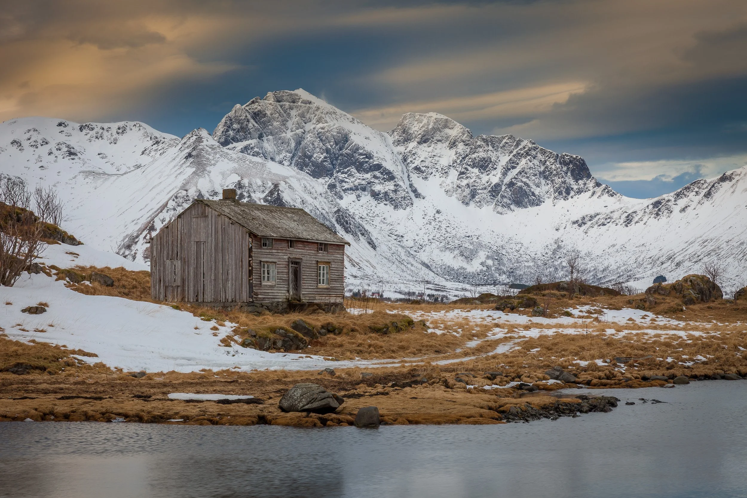 Cabin in the Lofoten Islands, Norway – cosy wooden cottage set between rugged mountains and the lake.
