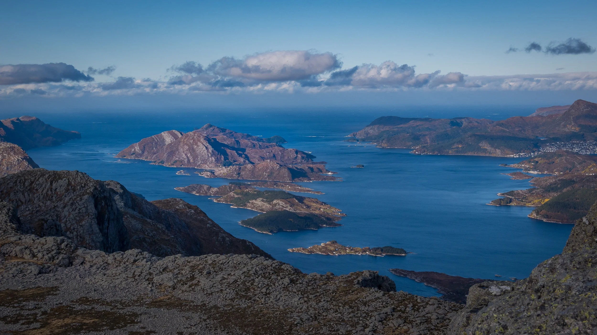 Utsikt fra toppen av Hornelen mot Husevågøy, med Bremangerlandet til venstre, Vågsøy til høyre og Stadhavet ute i horisonten. Bildet viser hvordan Husevågøy ligger ytterst i Nordfjorden, mellom fjordlandskapet, øyene og det åpne havet.