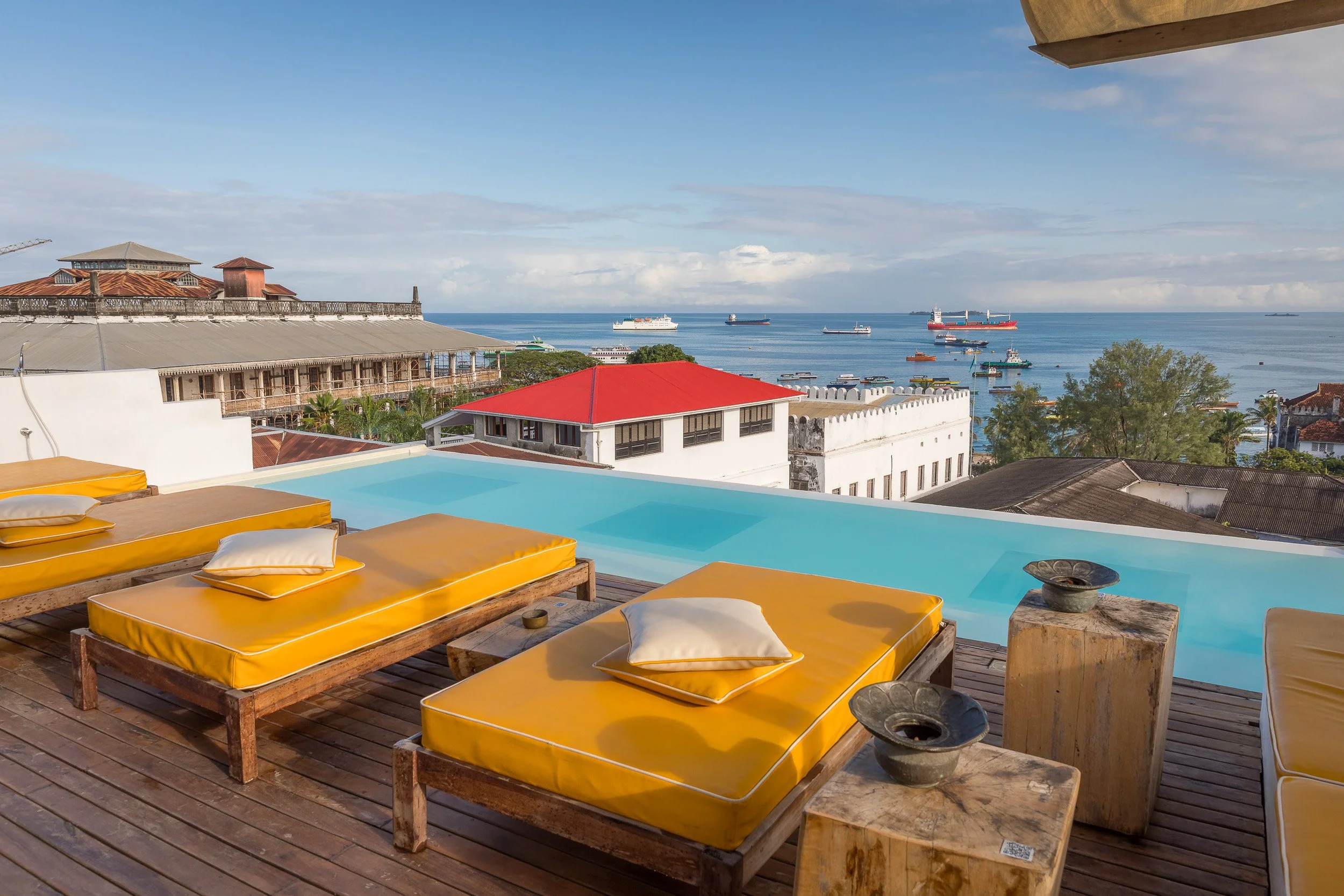 Rooftop terrace at Upendo House in Stone Town, Zanzibar – cosy seating, lanterns and rooftop views across the old town towards the tropical Indian Ocean.