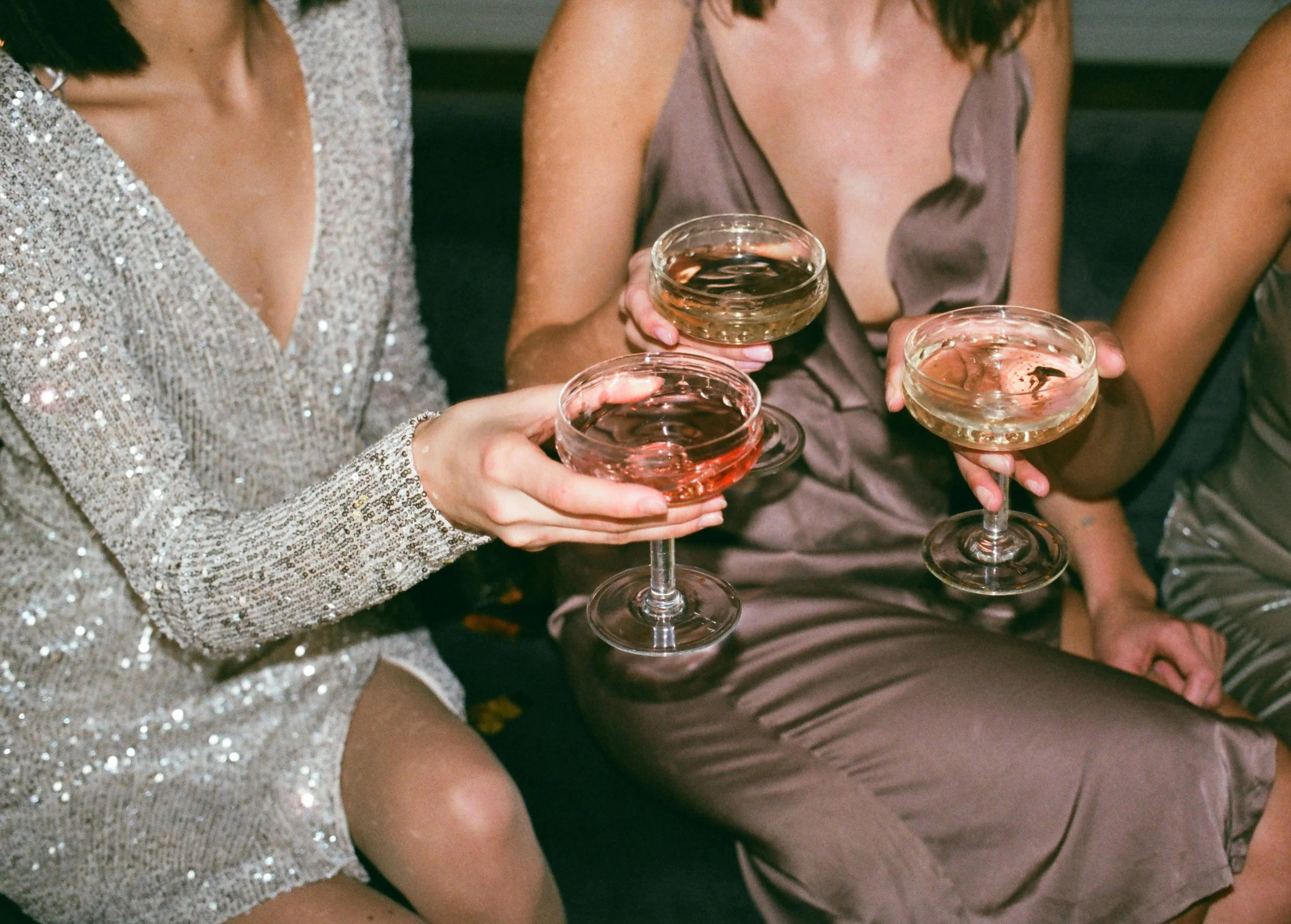 Freundinnen mit Drinks bei einer Styling Party als gemeinsames Mode- und Styling-Event.