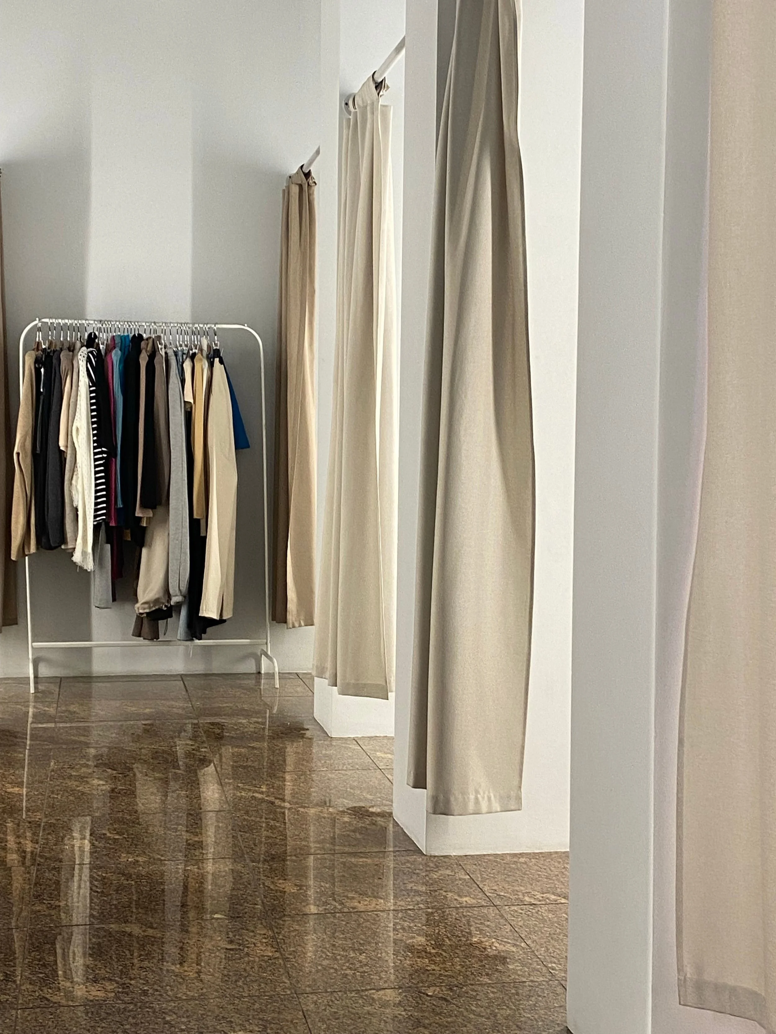 Kleiderstangen mit ausgewählten Outfits als Symbol für persönliche Stilberatung beim Shopping