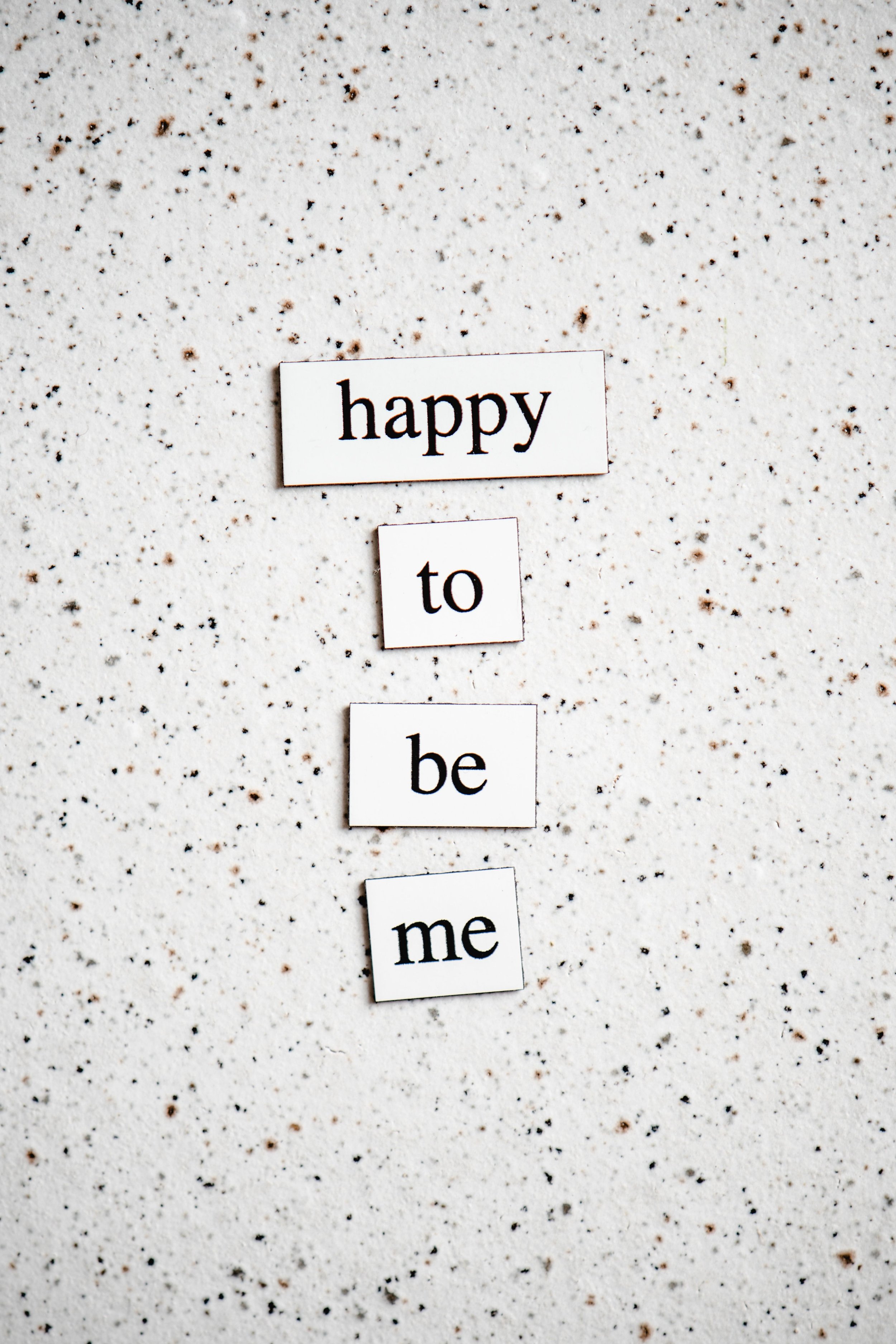 Kärtchen mit der Aufschrift „happy to be me“ als Symbol für Selbstannahme und Selbstbewusstsein