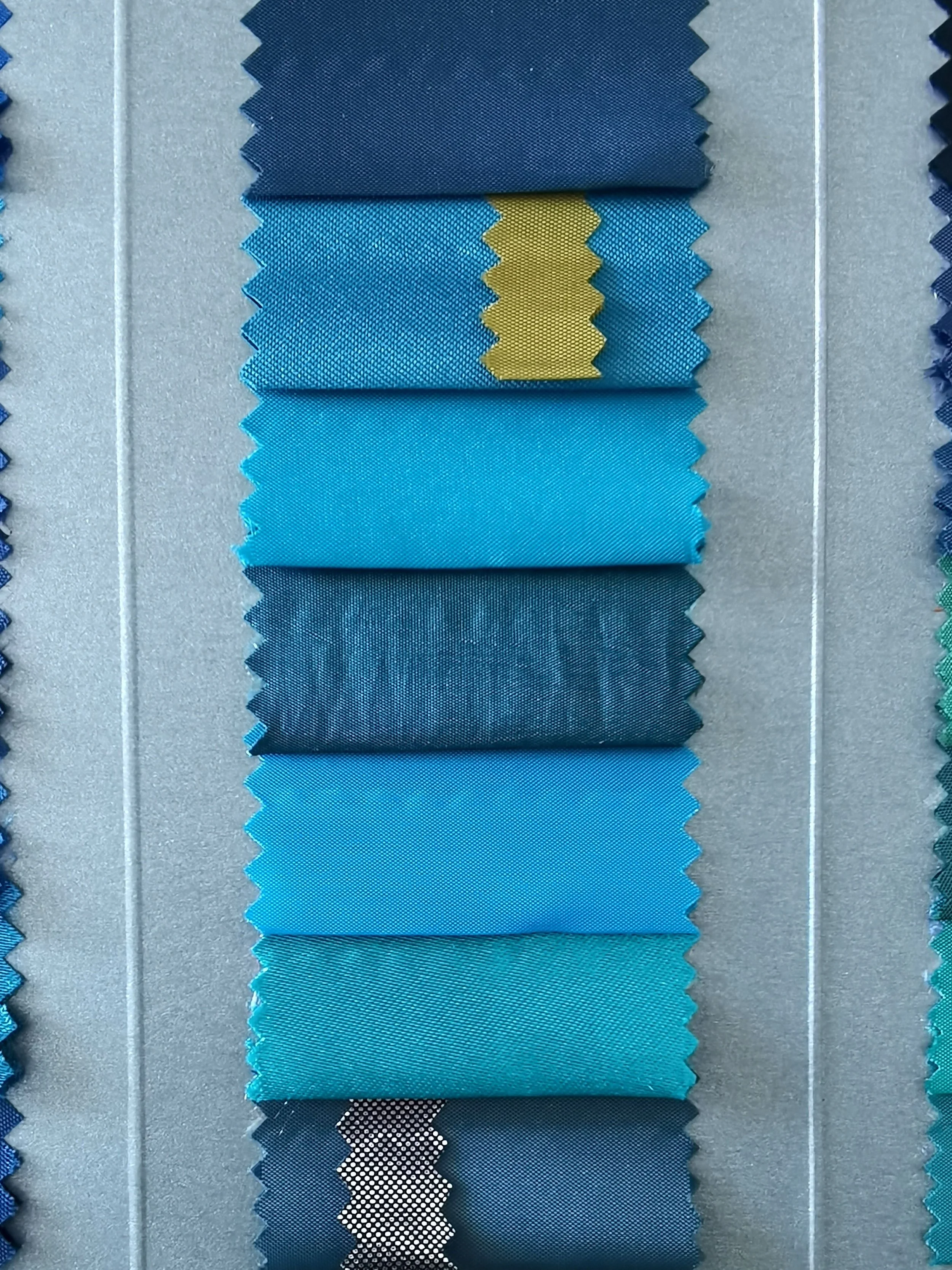 Ansicht verschiedener Blautöne als abgestufte Stoffstreifen zur Analyse von Kontrast und kühlen Farben in der Farbtypanalyse von The Neutral Blazer.