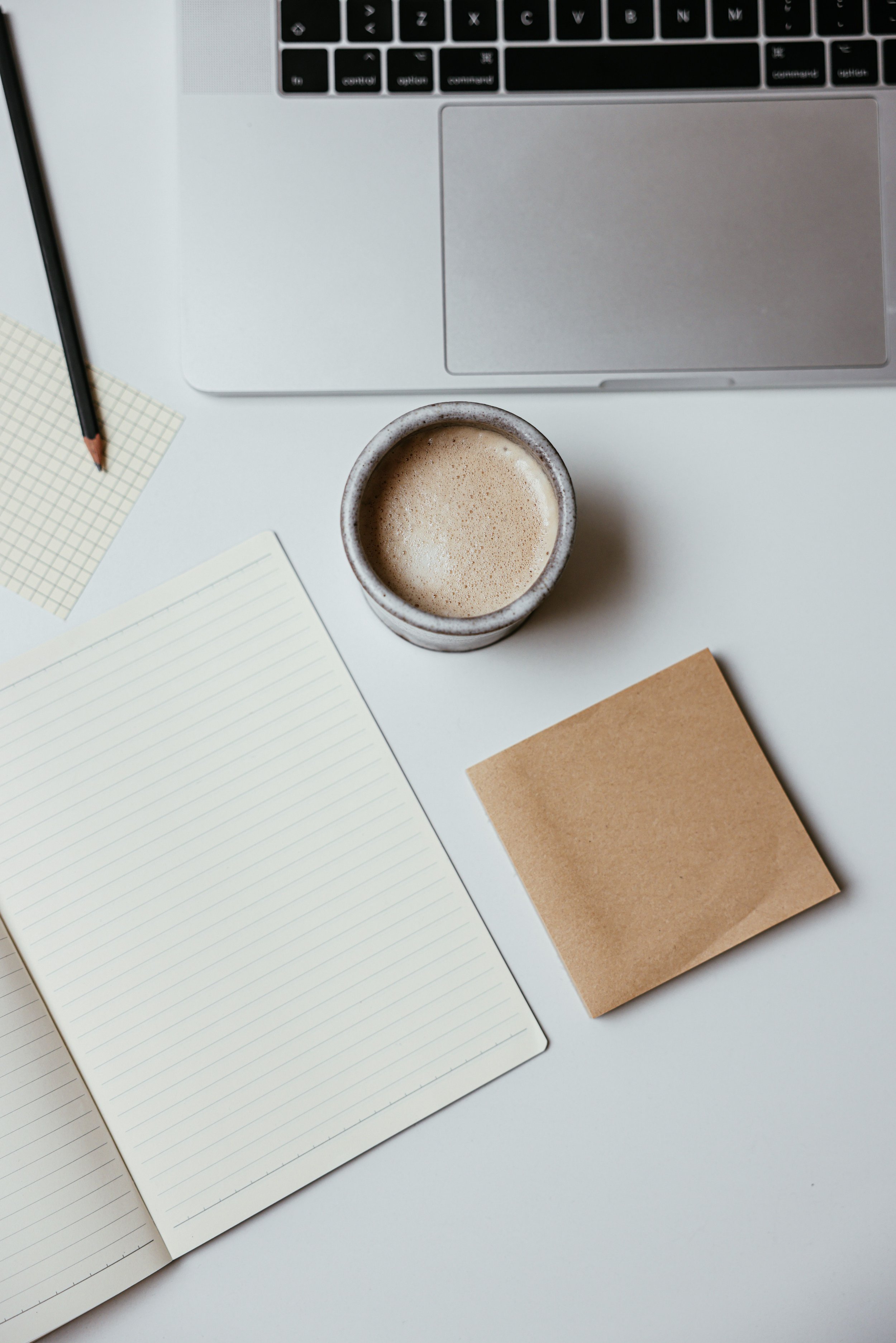 Notizbuch und Kaffee als Symbol für Reflexion, Journaling und persönliche Weiterentwicklung