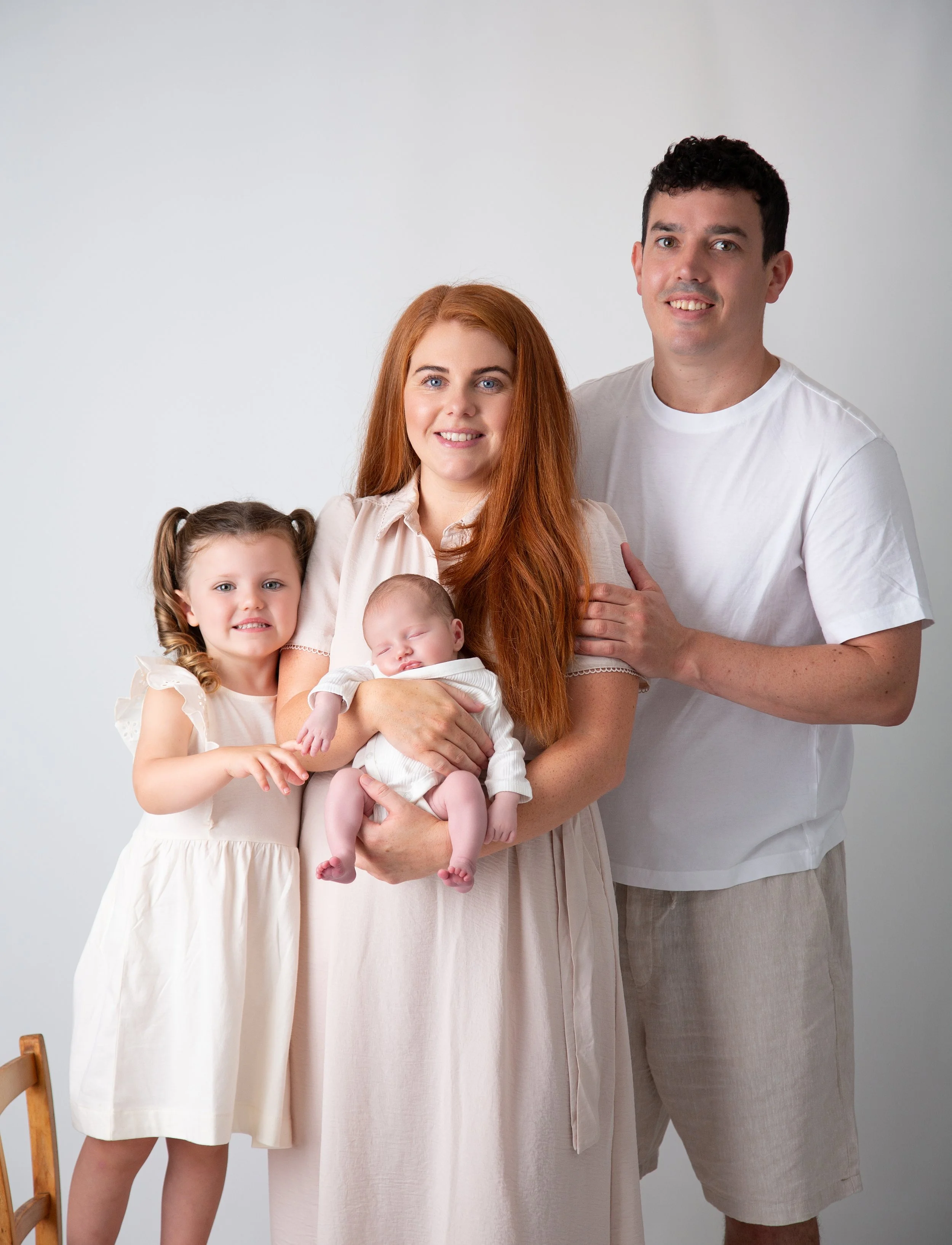Family with a toddler and a newborn baby in cream and white outfits, family photographer in Upminster