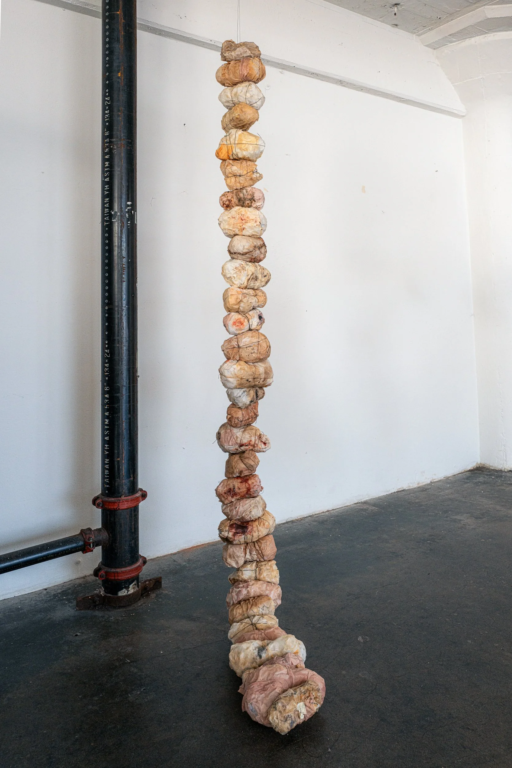 UNTITLED (FAT BALLS), 2025 | 123" x 11" x 10" | Paper, polyester fill, beeswax, thread, and industrial wire, kevlar thread, and resin