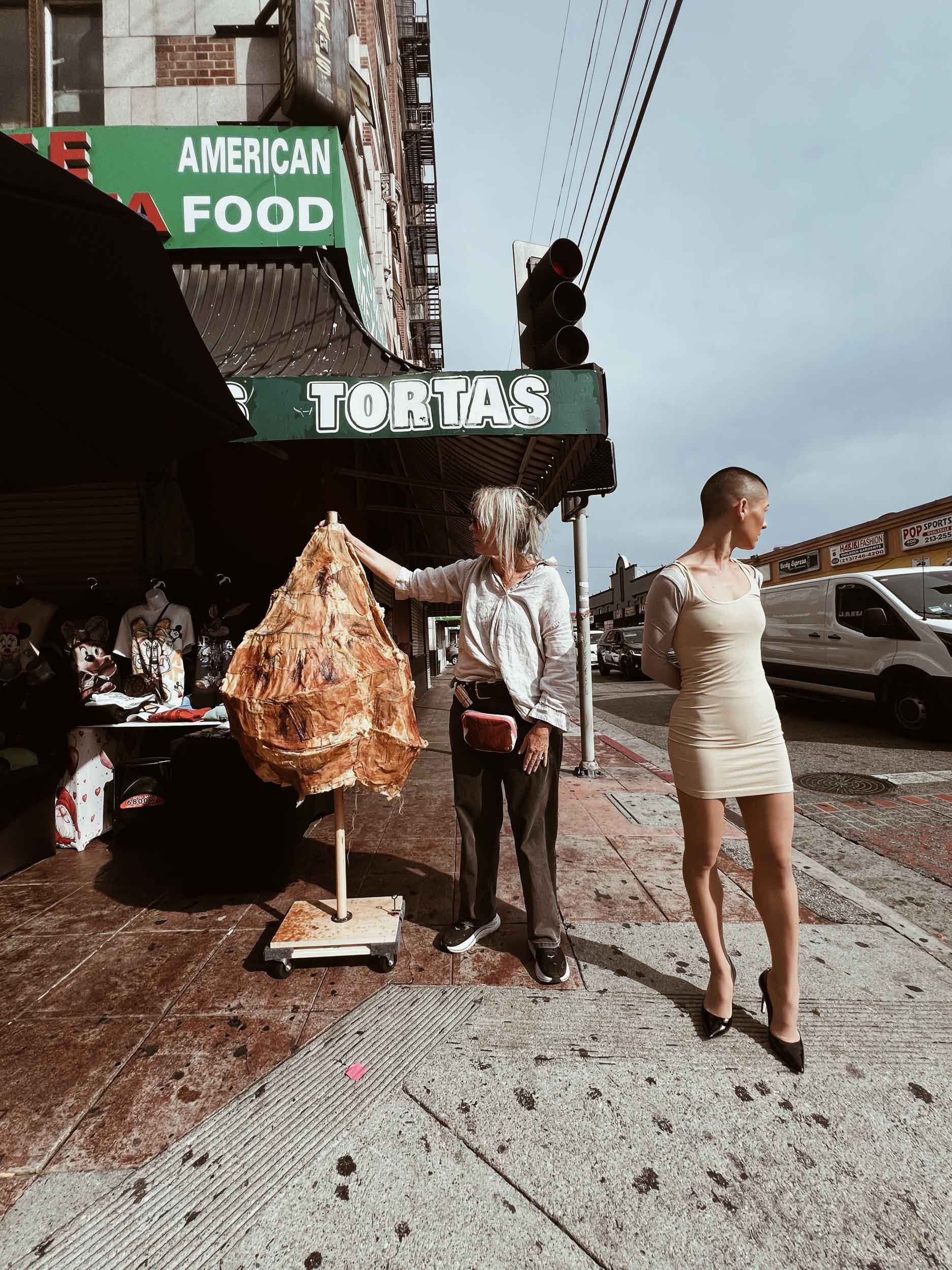 Artist Frankie Holt in Downtown Los Angeles Fashion District on street with dancer, model preparing for shoot