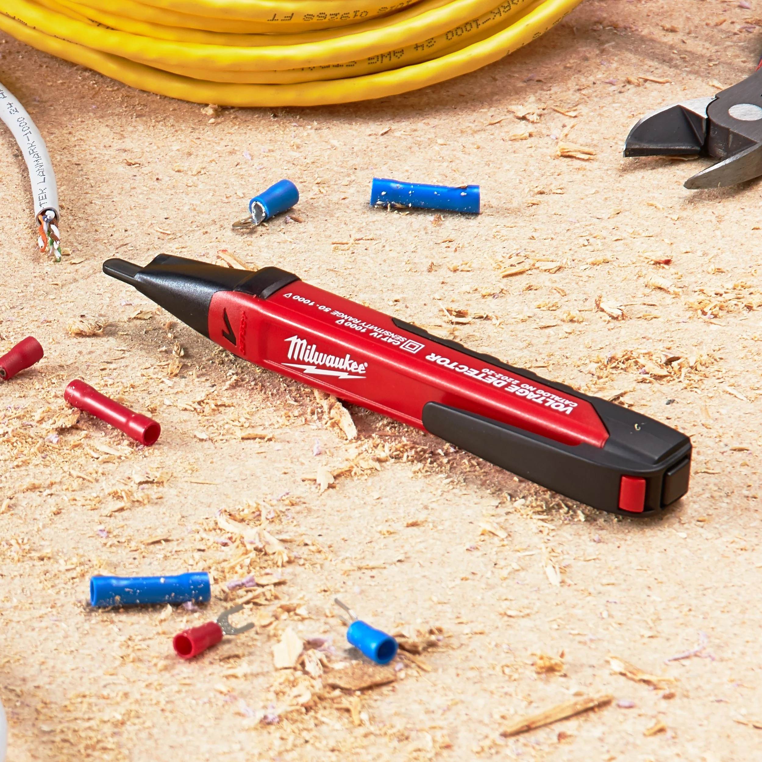 A work surface with scattered wire connectors, a utility knife, and a red Milwaukee marker.