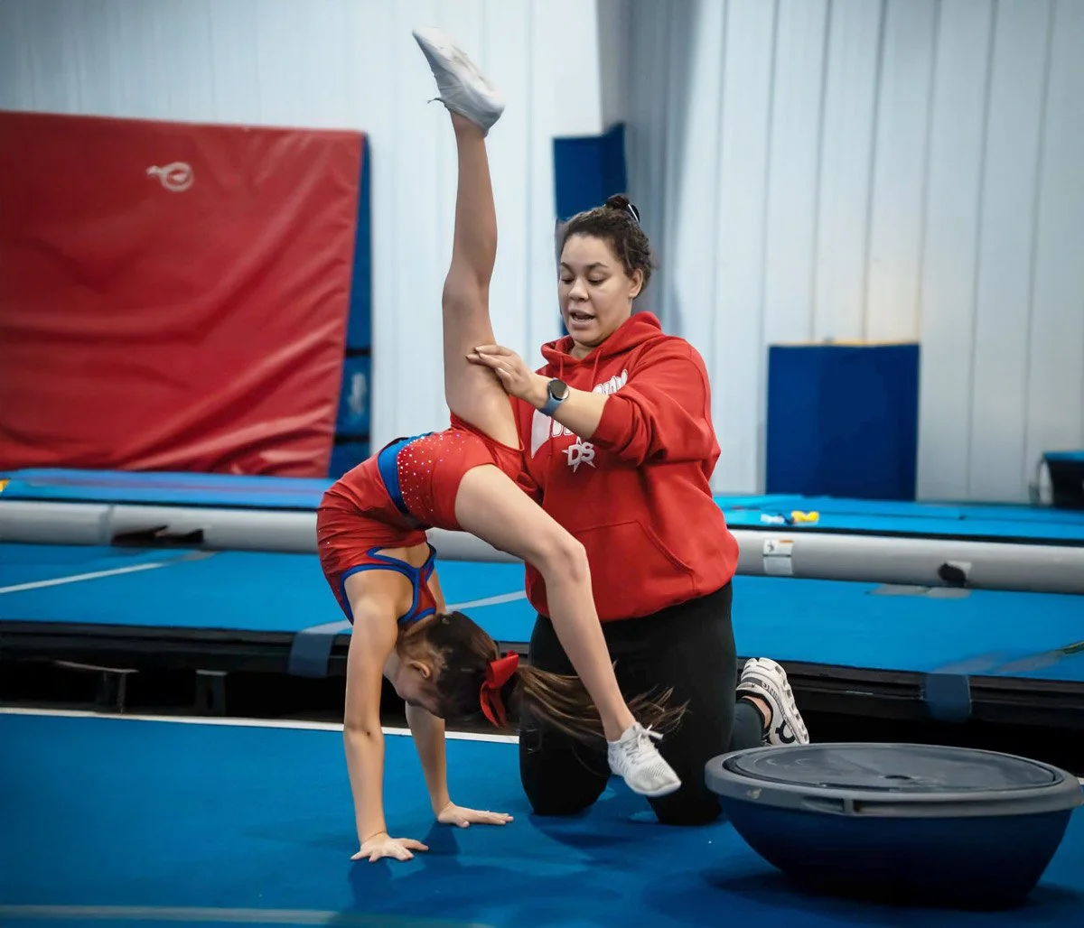 Athlete performing a stunt with the help of a coach.