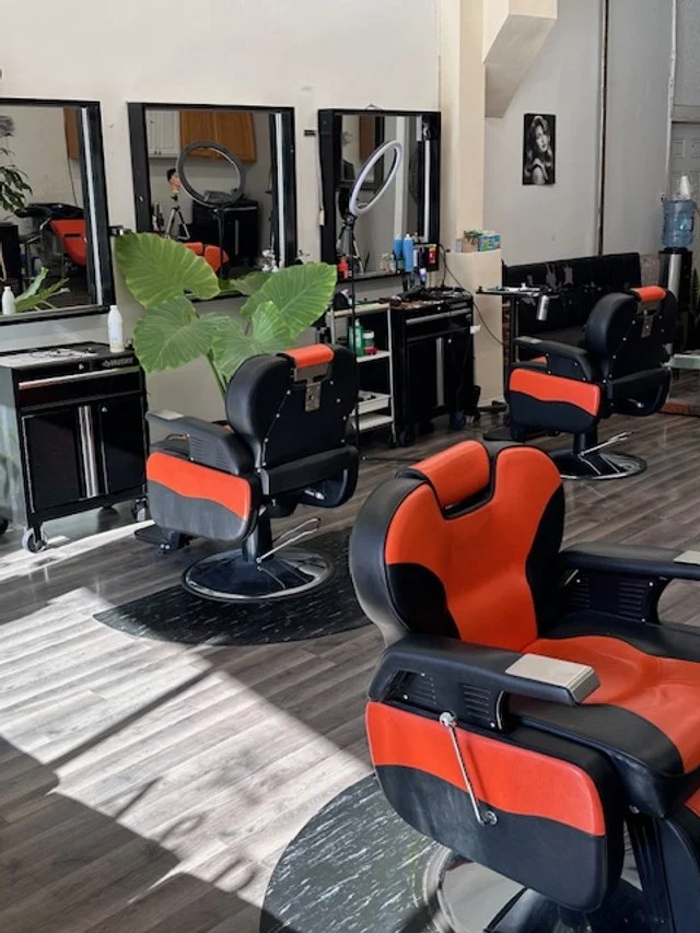 Interior of a Chicago barbershop with black and orange barber chairs,
mirrors, and organized workstations in a clean modern space.