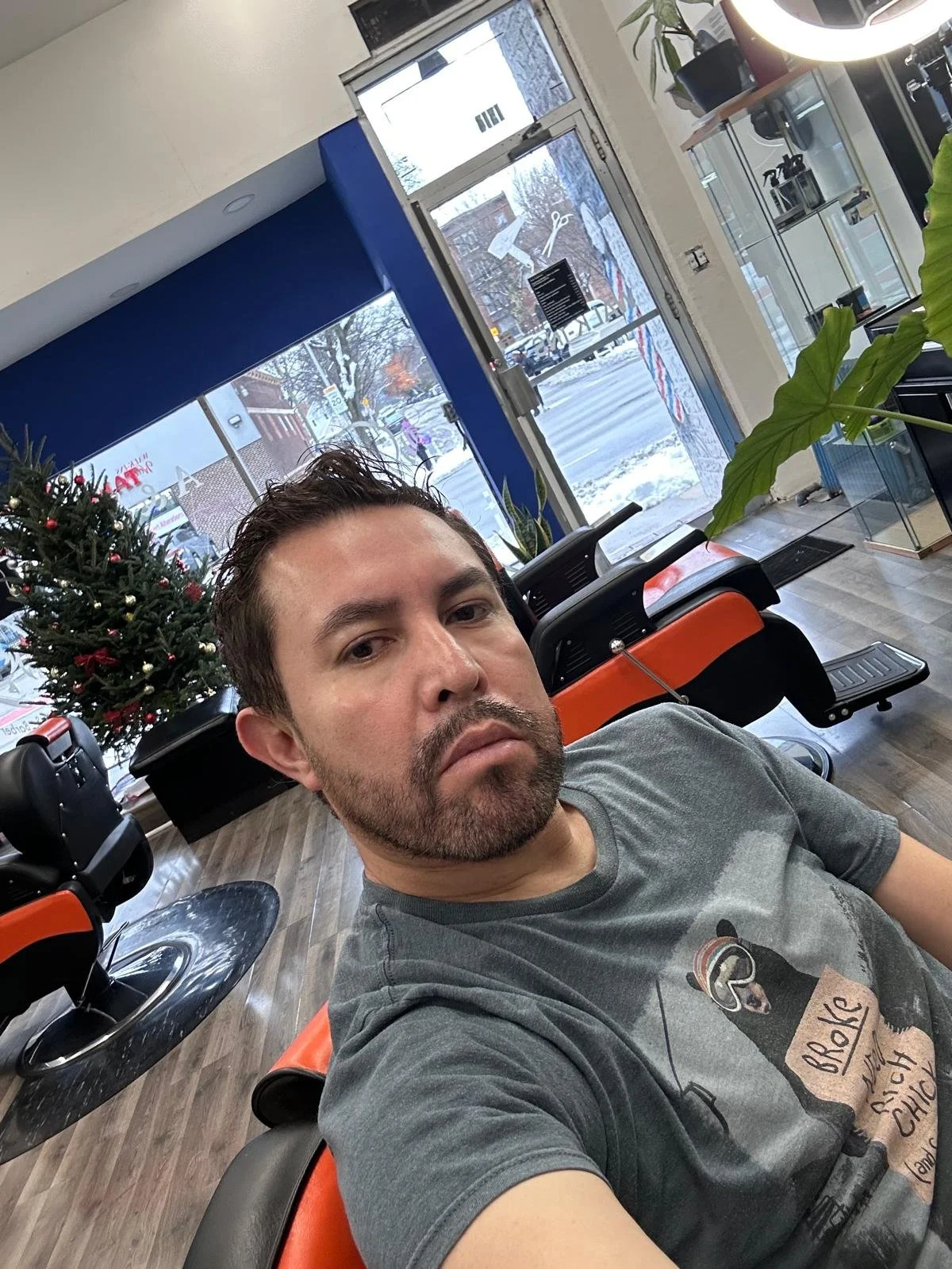 Astari of A&B Barbershop in Chicago inside the barbershop, showing the clean and modern shop with barber chairs and holiday decorations.