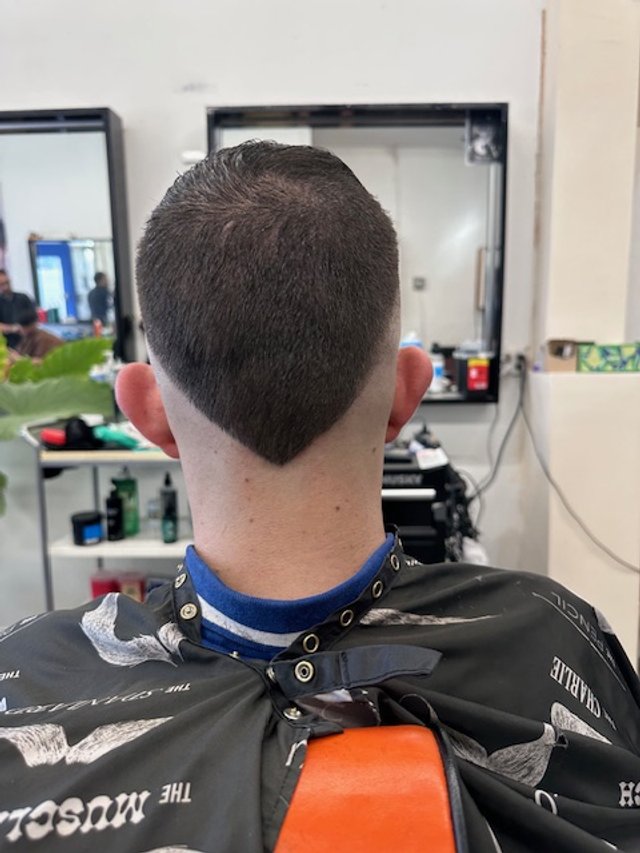 Clean neckline design on a men’s haircut at a Chicago barbershop,
showcasing sharp detailing and precise clipper work