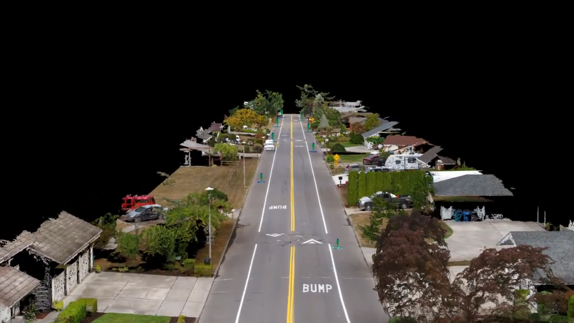 Aerial view of a residential neighborhood with a clear road marked with a yellow dividing line and the word 'BUMP' painted on it. Houses, trees, and vehicles line the street on both sides, with a black void on the top and sides of the image.
