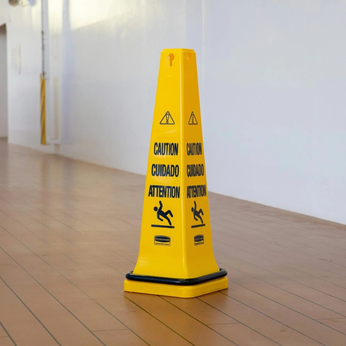 Yellow caution/wet floor sign on a wooden floor.