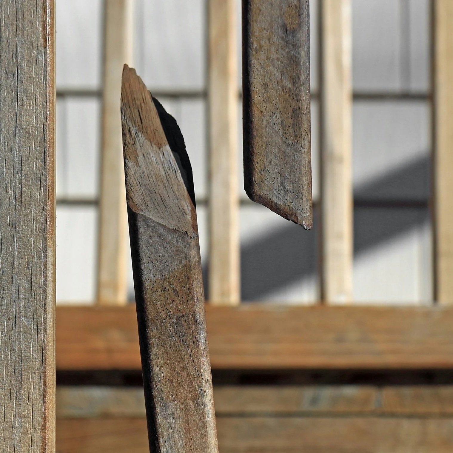 Close-up of wooden slats, with peeling paint and weathered surfaces, arranged in a grid pattern.
