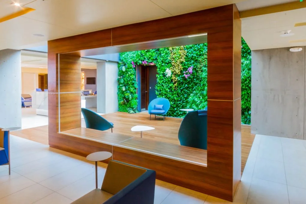 Modern hotel lobby with a green living wall and seating area