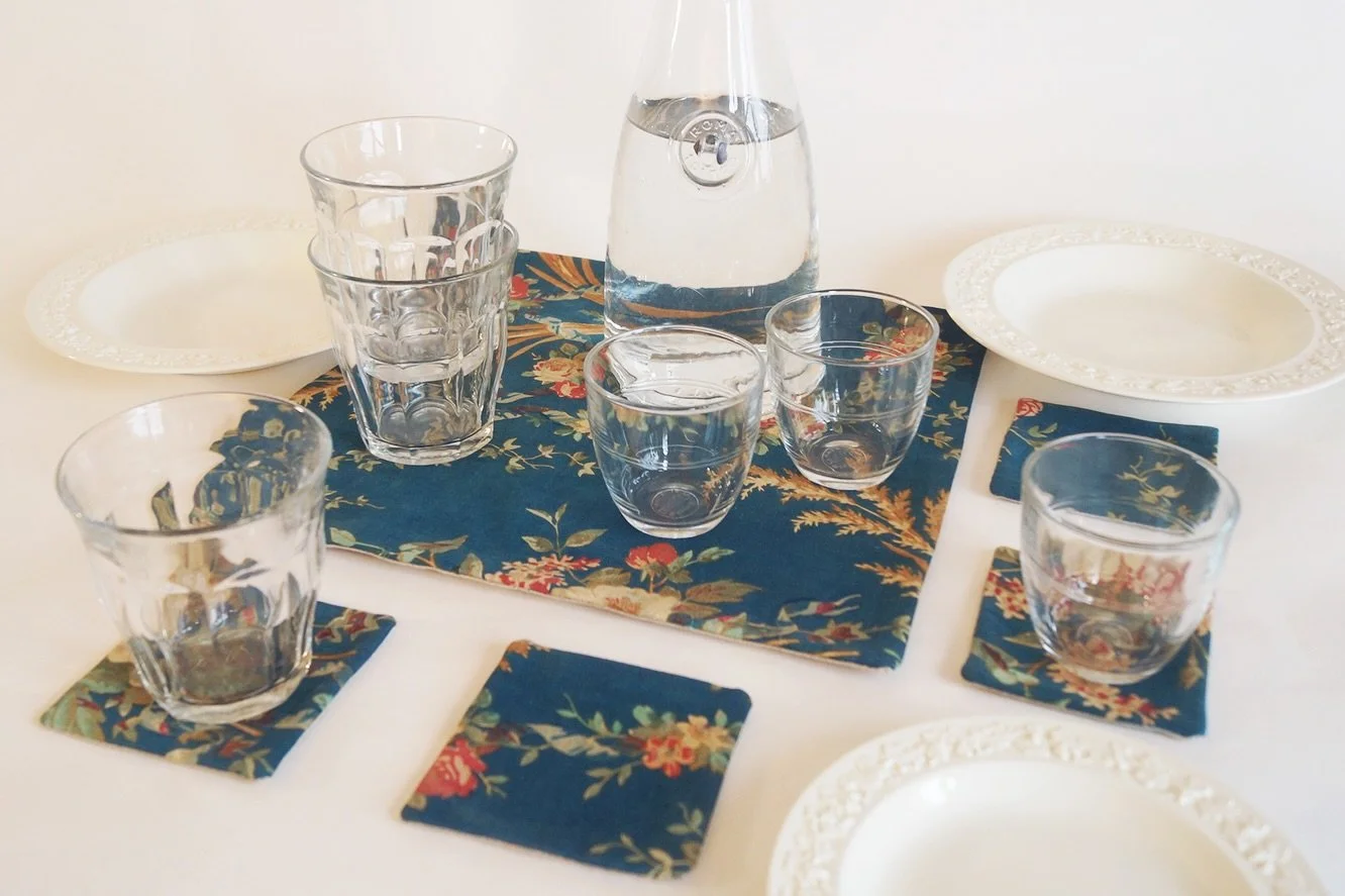 19th-Century French Floral Table Mat &amp; Coaster Set, No.2
💐
Set your table as if setting a scene from a forgotten French garden.
This table mat and coaster set is crafted from a 19th-century textile alive with wandering vines, soft blooms, and th