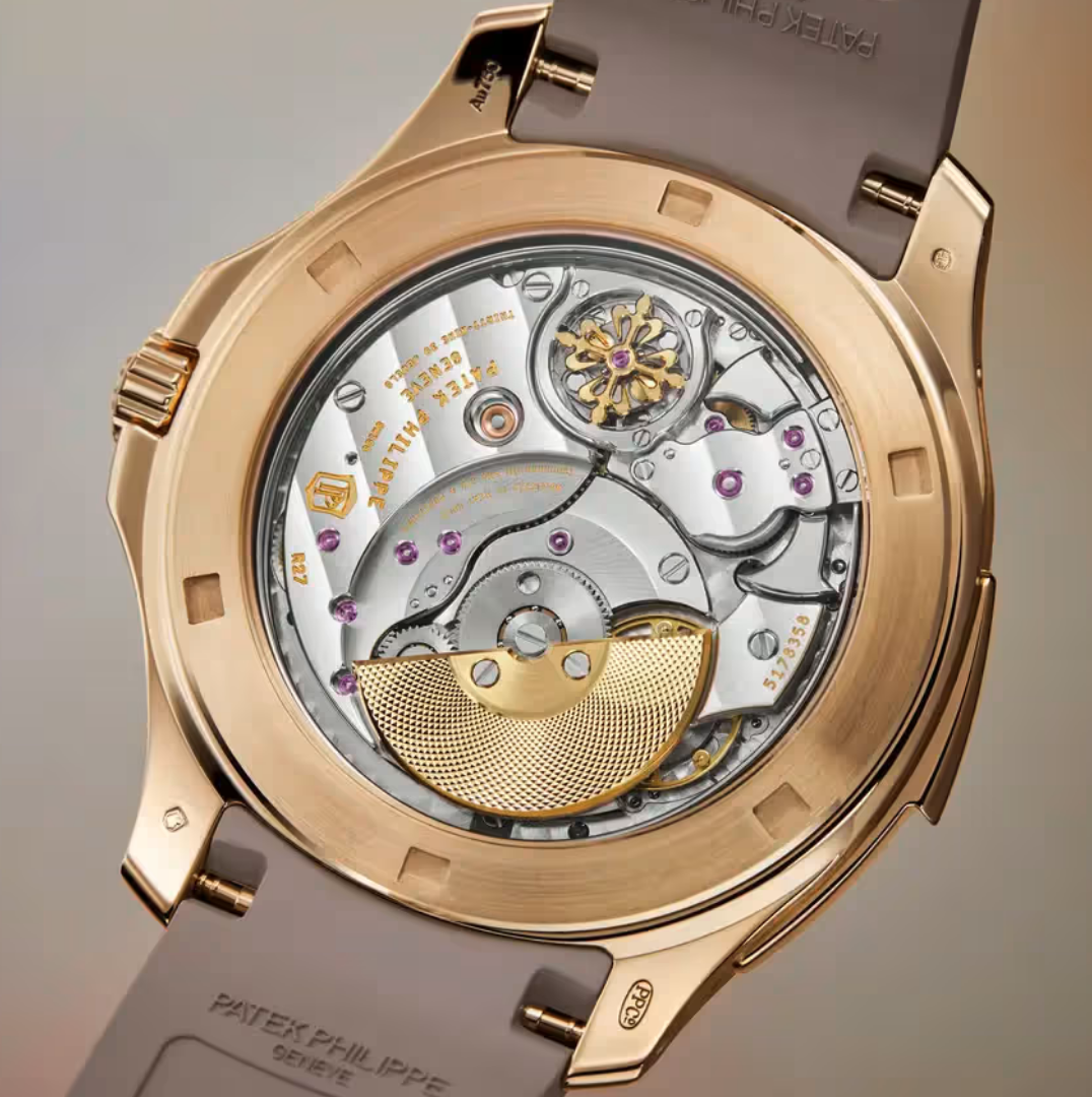 Close-up of a luxury wristwatch's intricate mechanical movement, featuring gears, purple jewels, and gold accents, with a gray strap.