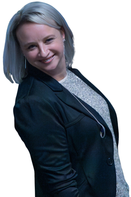A smiling woman with shoulder-length blonde hair wearing a dark blazer over a sparkly top, against a black background.