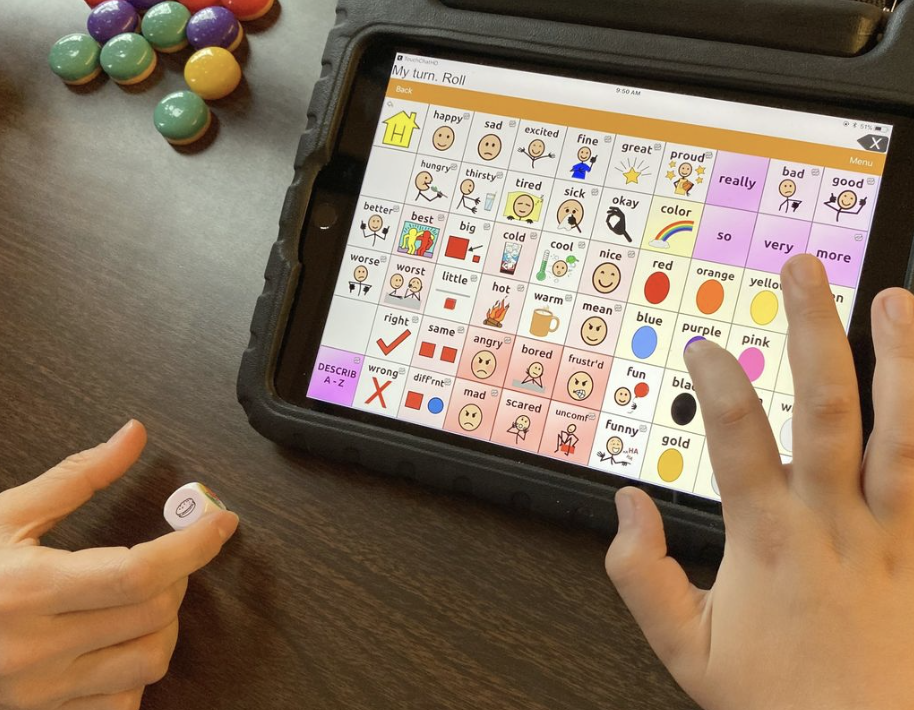 Child using communication device during community-based therapy in Bellingham, Washington.