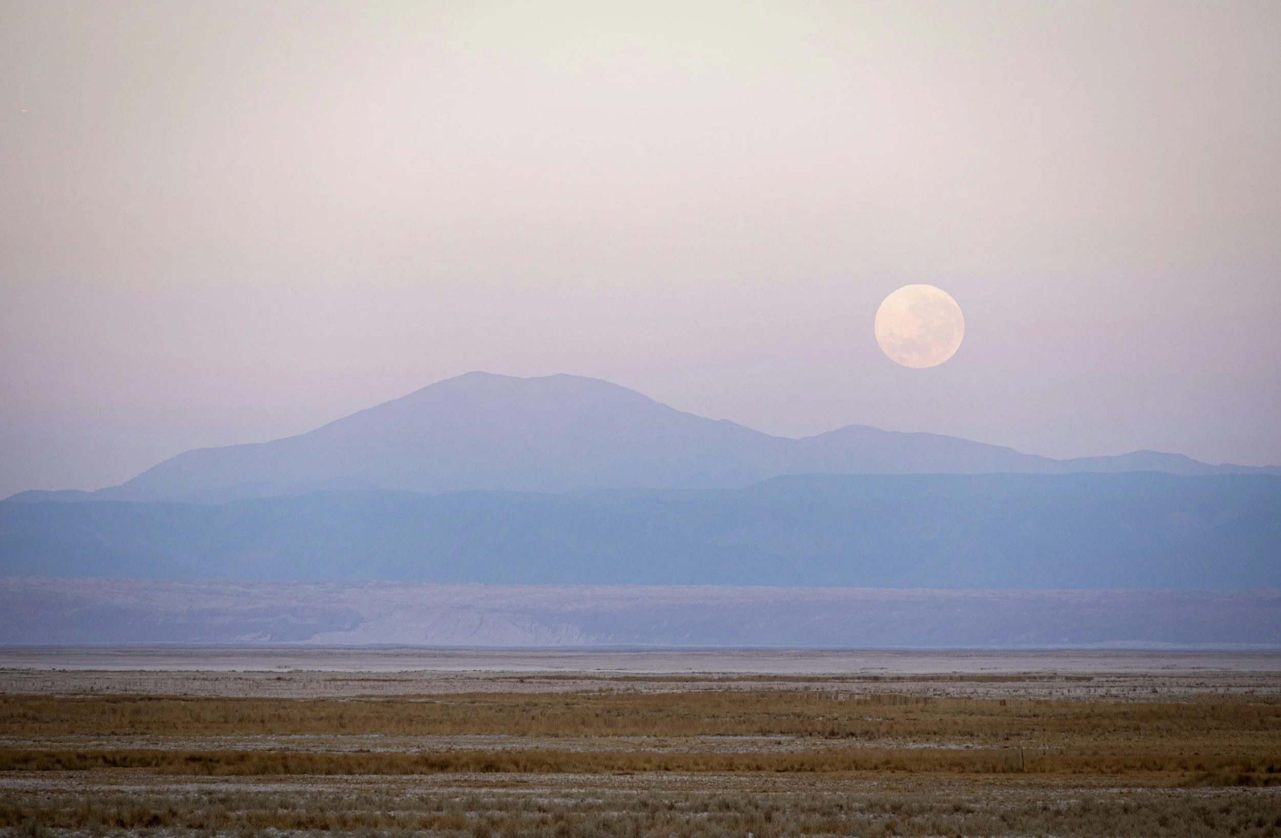 A desert scene with a the moon