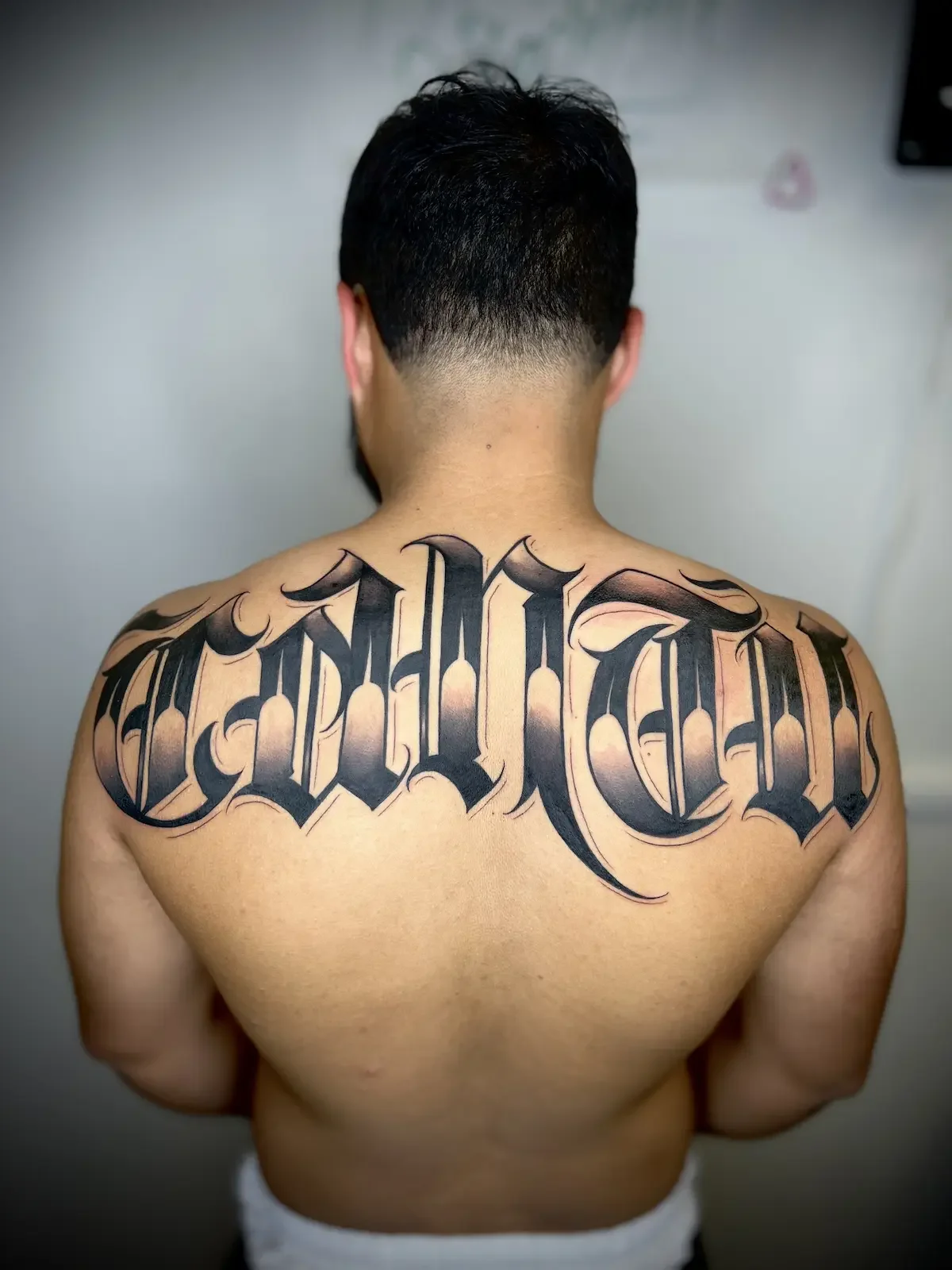 Large custom lettering tattoo done by best tattoo artist Johny Vasquez Mommasboy Tattoo Austin TX