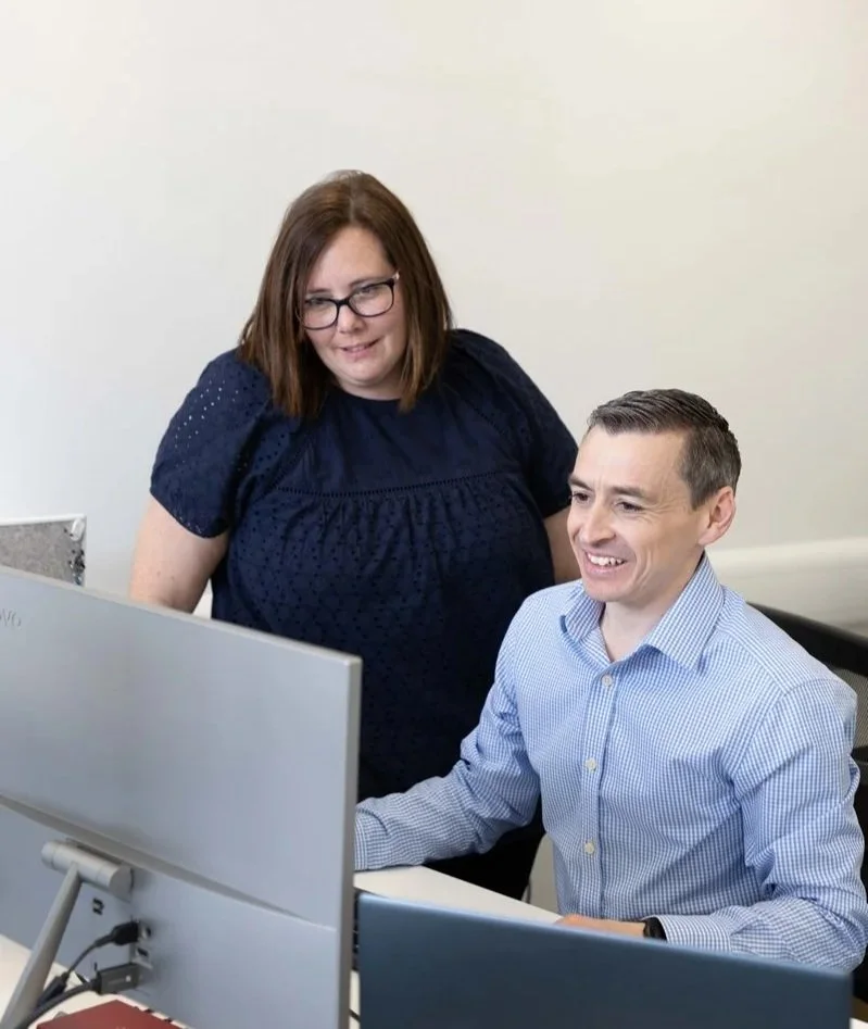 Man and woman looking at a computer screen in a modern office UK